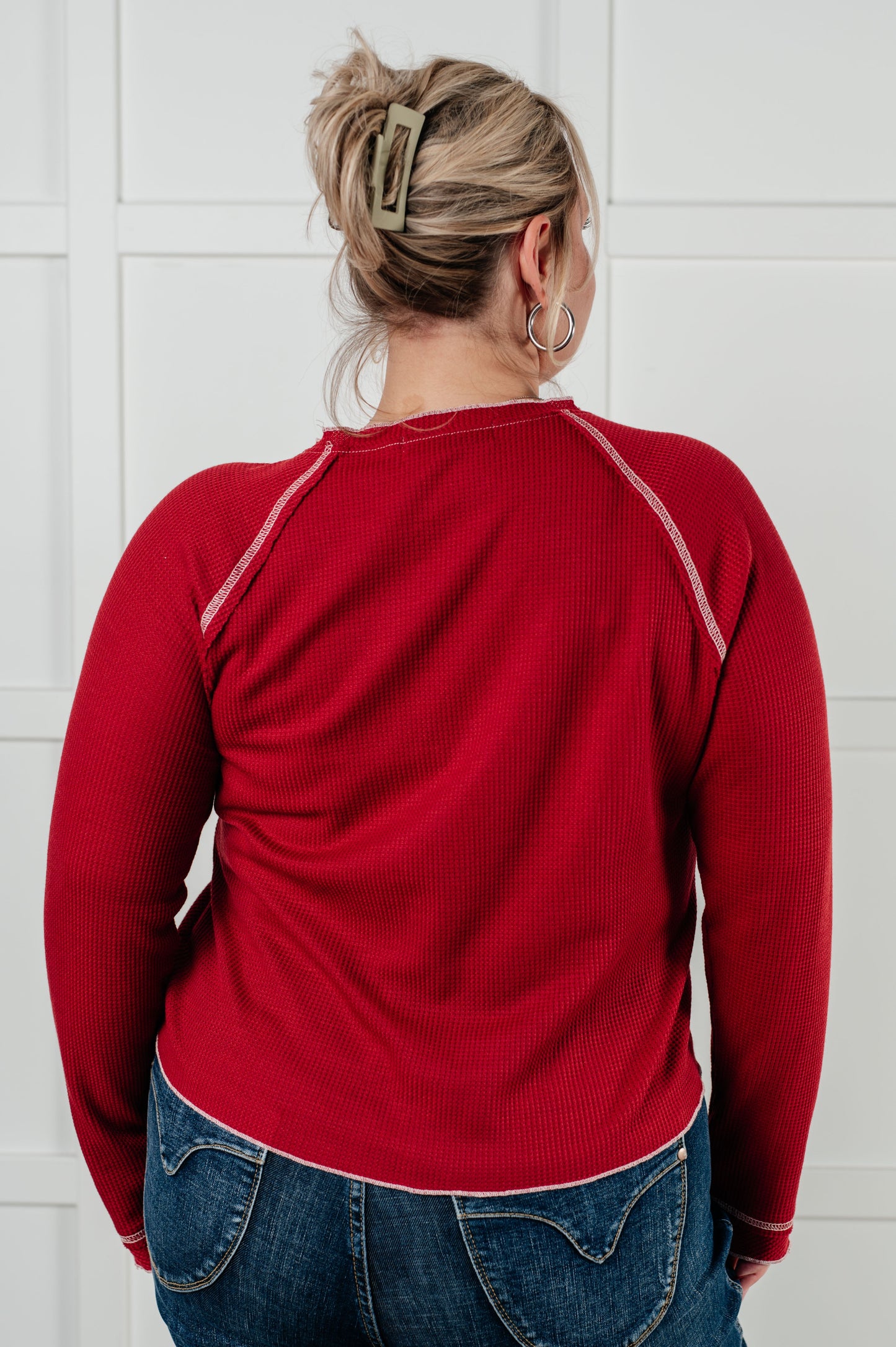 Back view of plus size model in Pavla Waffle Knit Top, red waffle knit with raw edge hem