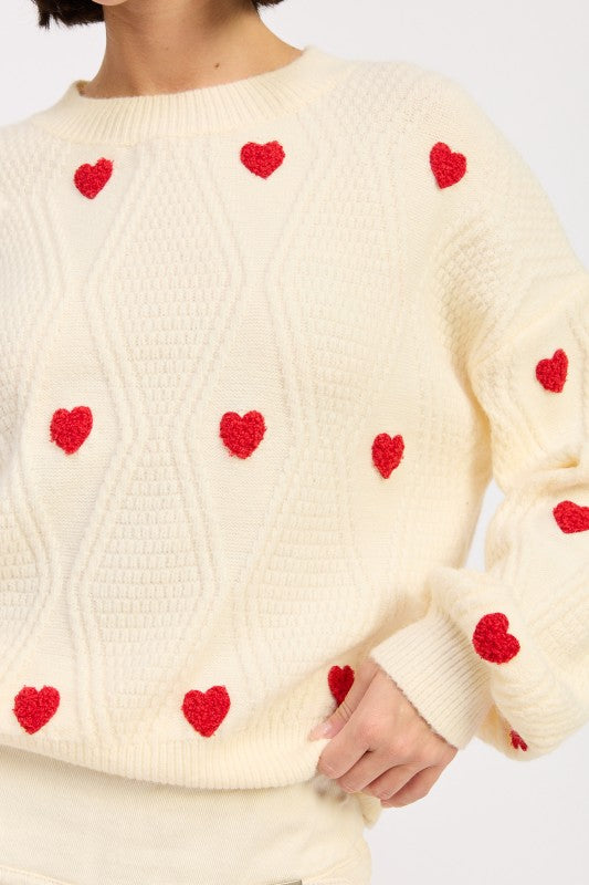 Close-up of Dana Embroidered Sweater showing red heart embroidery detail.
