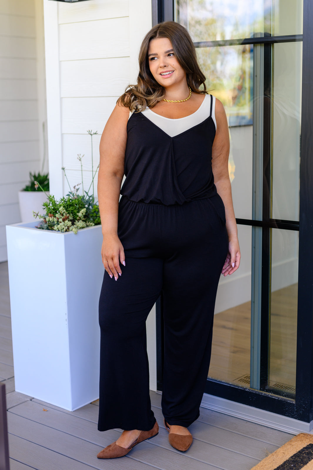 Plus size model full body view wearing Viola Jumpsuit in Black with flats