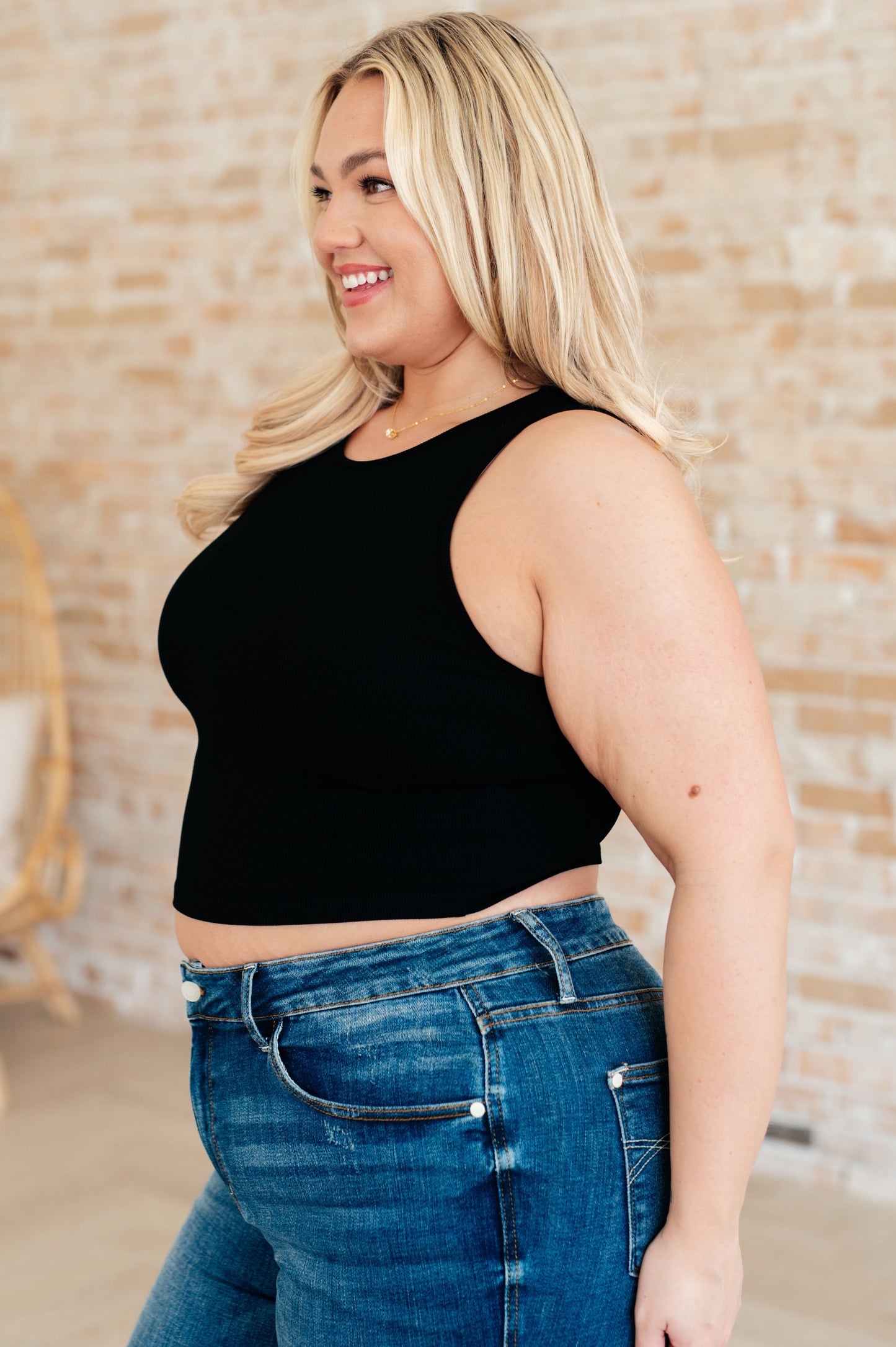 Side view plus size black rib knit cropped tank top with round neckline, sleeveless layering essential.