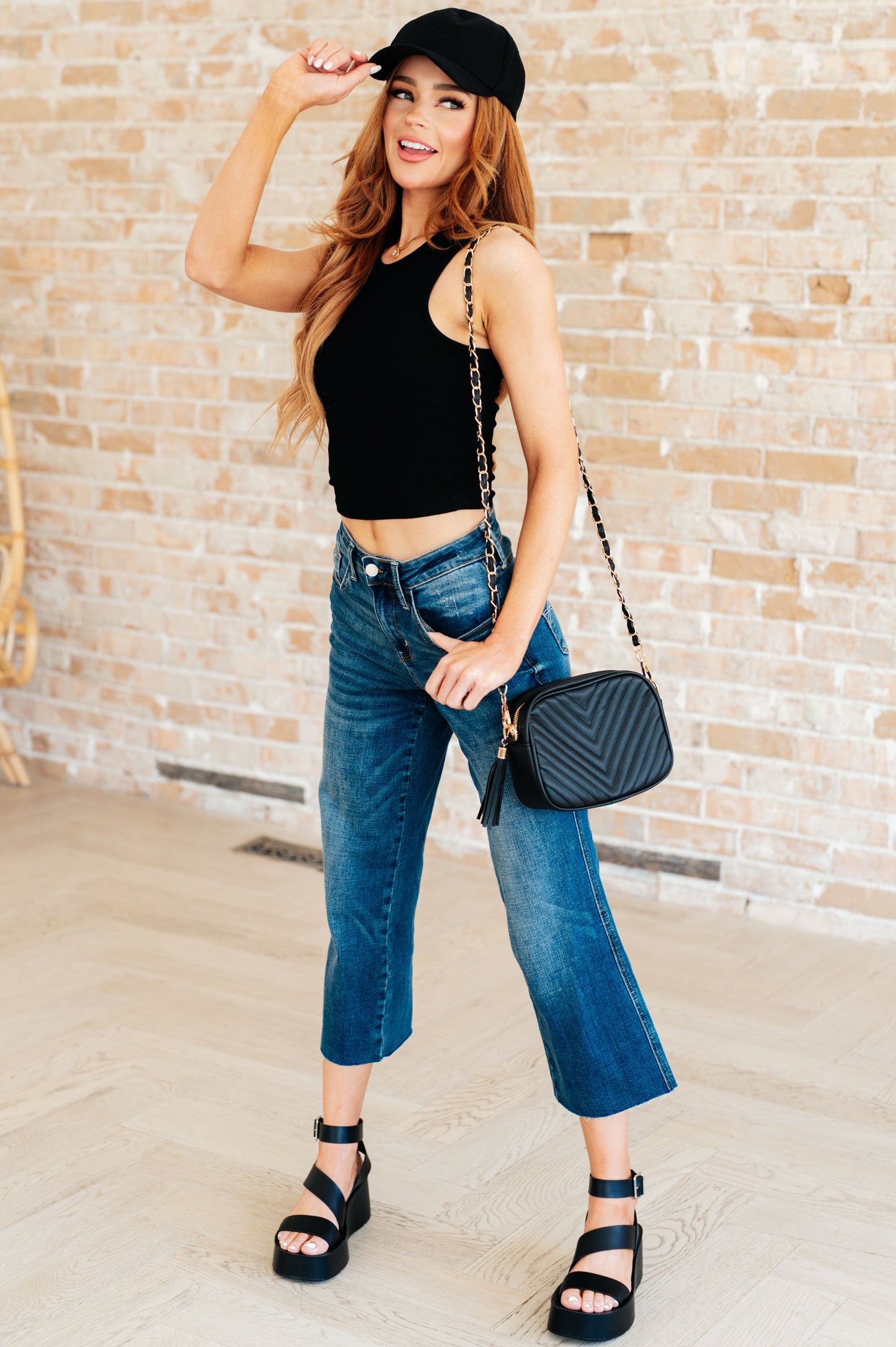 Black ribbed knit crop tank top front angle, round neckline, sleeveless style, chic trendy summer layering piece.