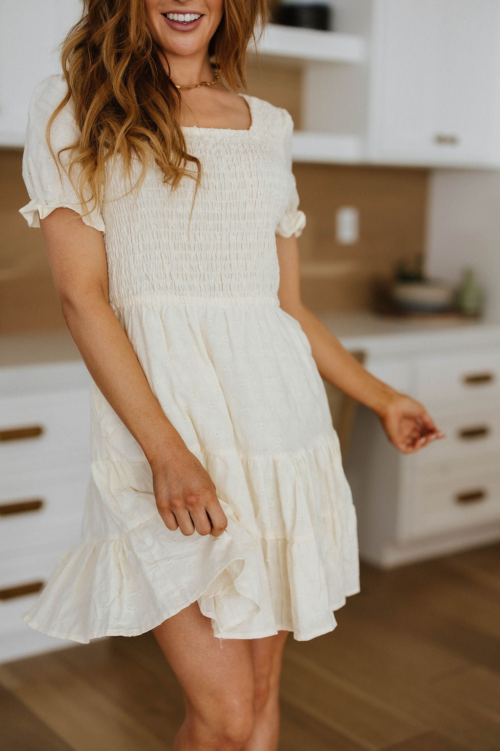 Kira dress with smocked bodice, square neckline, and tiered skirt – feminine and breathable cotton style.