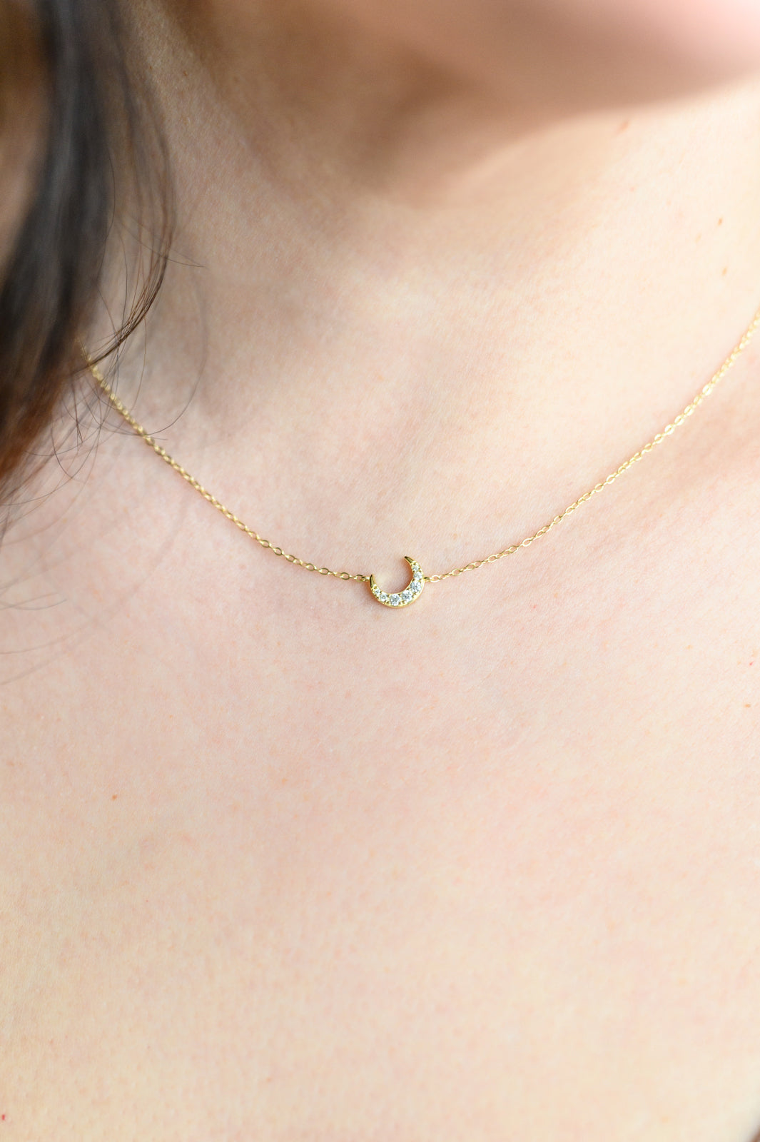 Woman wearing sterling silver moon pendant necklace with adjustable chain.