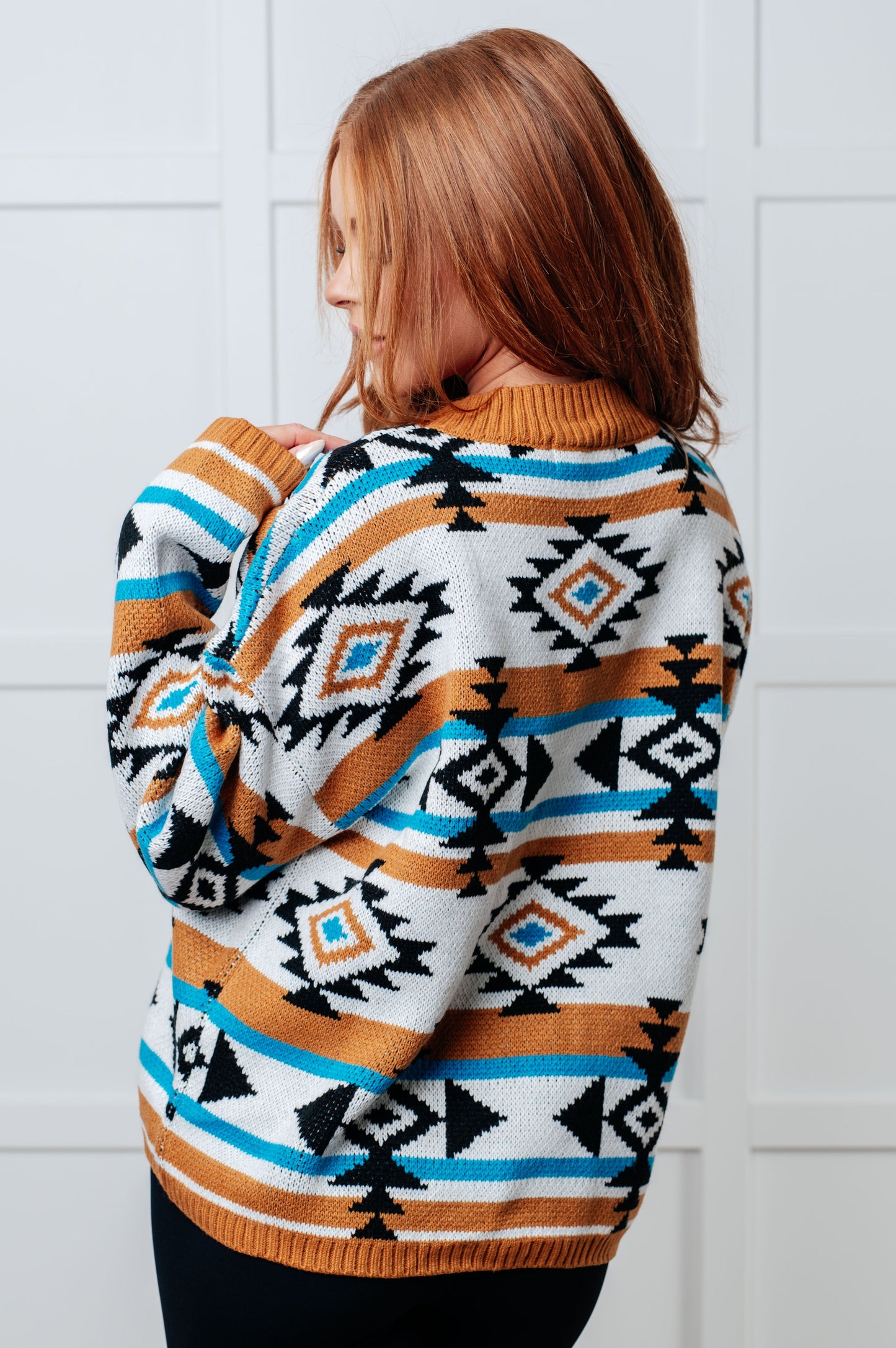Back view of Anza Geometric Striped Sweater with rust, black, and blue geometric stripe pattern