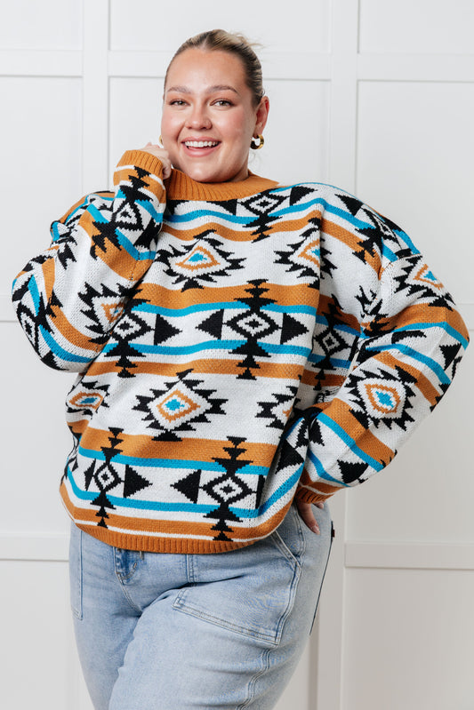 Plus size model front view wearing Anza Geometric Striped Sweater in rust geometric stripes