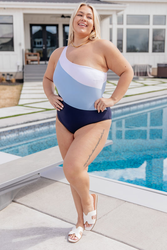 Plus size model in Dominica asymmetrical color block swimsuit, front view.