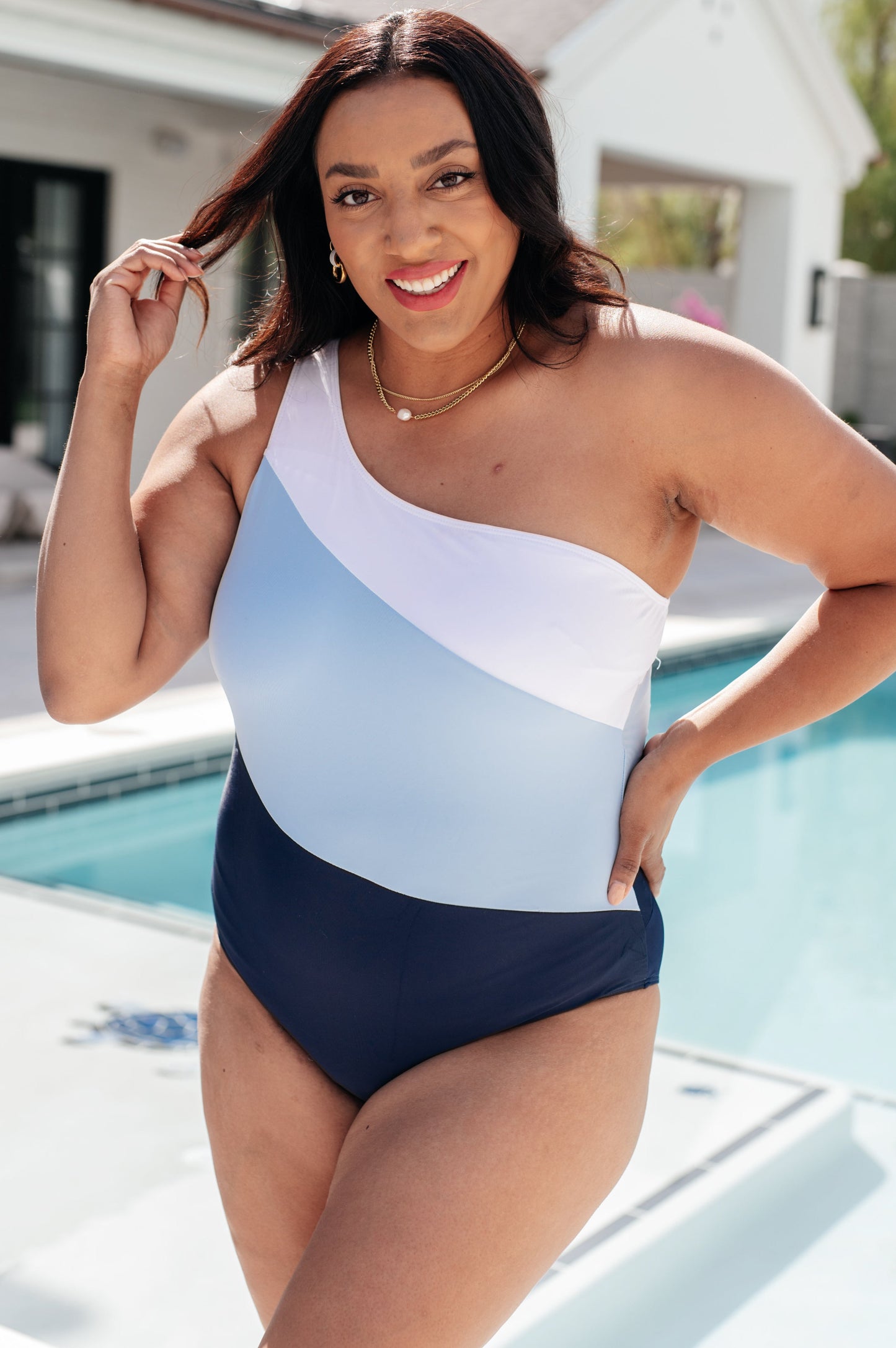 Asymmetrical Dominica Swimsuit in blue with a bold color block pattern, one-shoulder style, removable cups, and a back cutout detail.