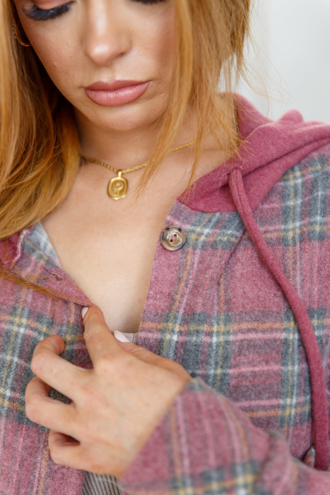 Women's Hooded Shacket in mauve plaid, featuring brushed plaid hacci fabric, hooded neckline, patch pocket, button front closure, and functional drawstring for a secure fit.