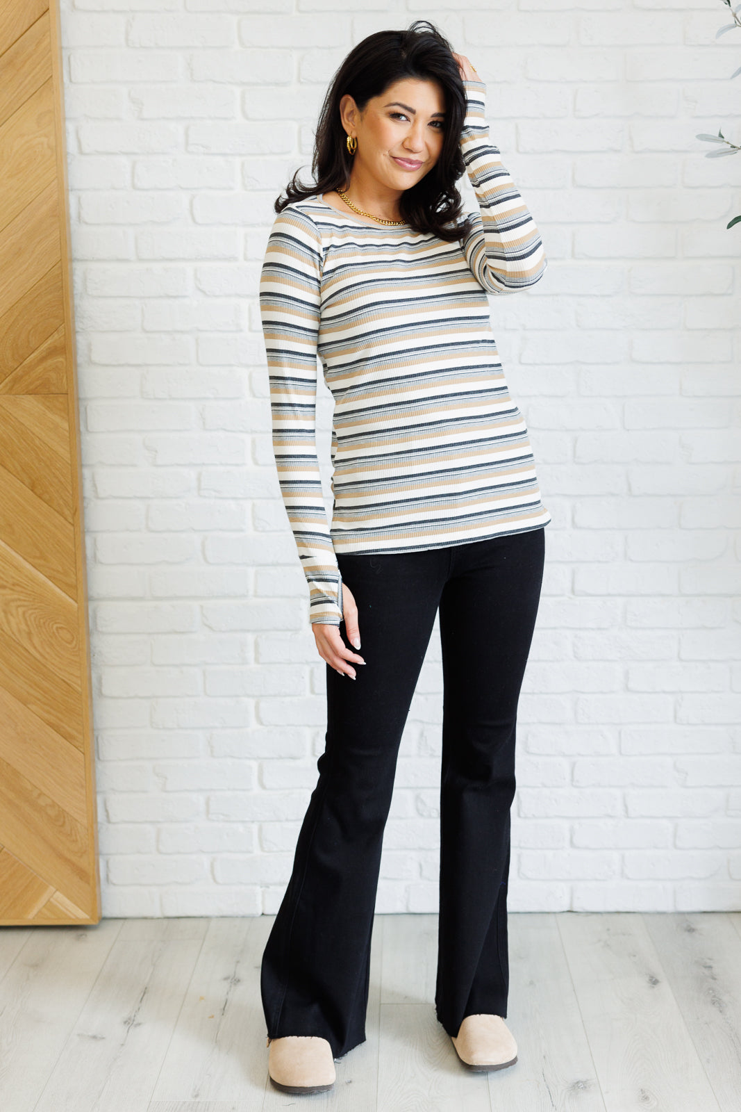 Full body view of Xavia Striped Top styled with jeans, featuring striped ribbed knit and side slit hemline.