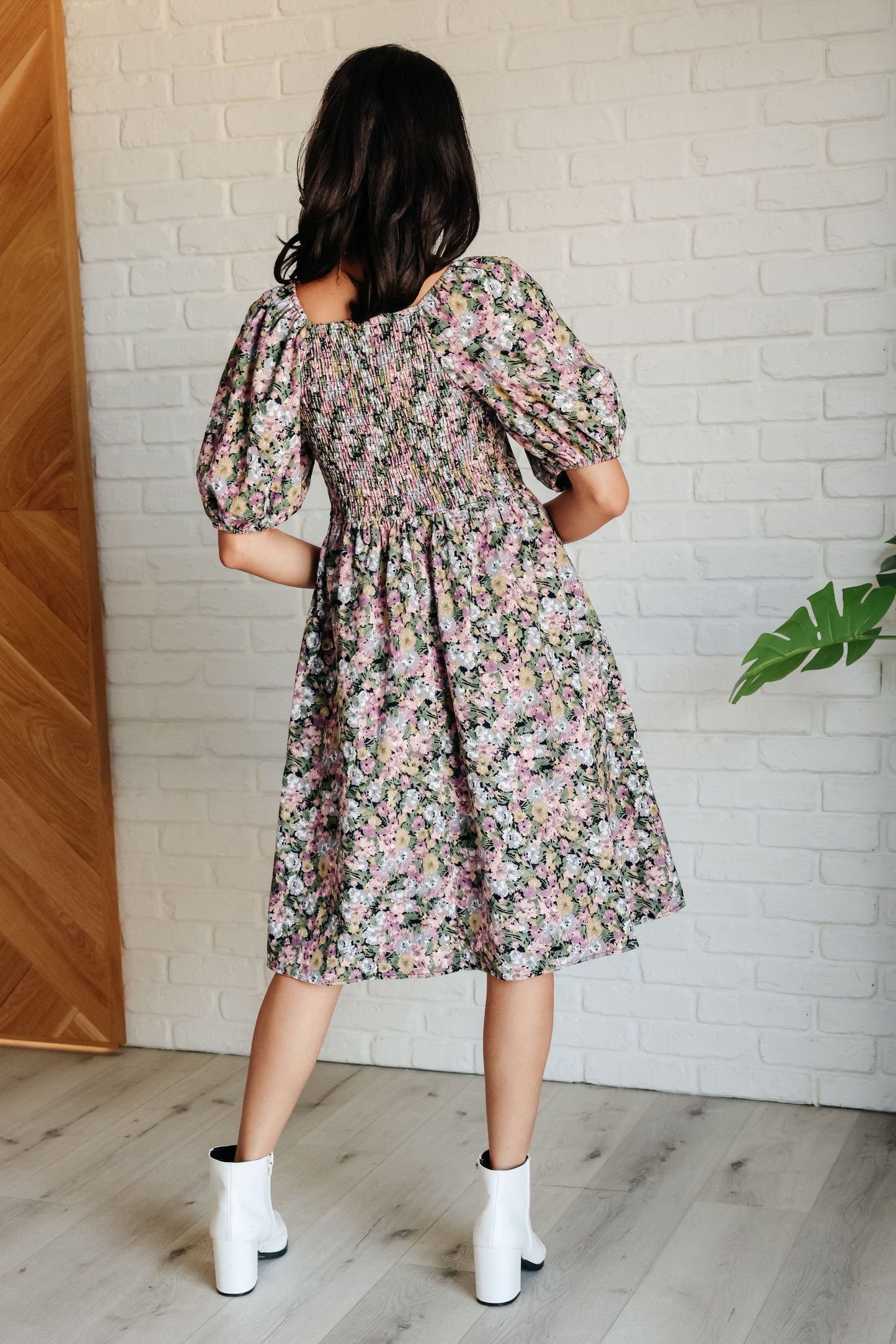 Back view of Skyla Floral Dress highlighting smocked fit and flowy floral skirt.
