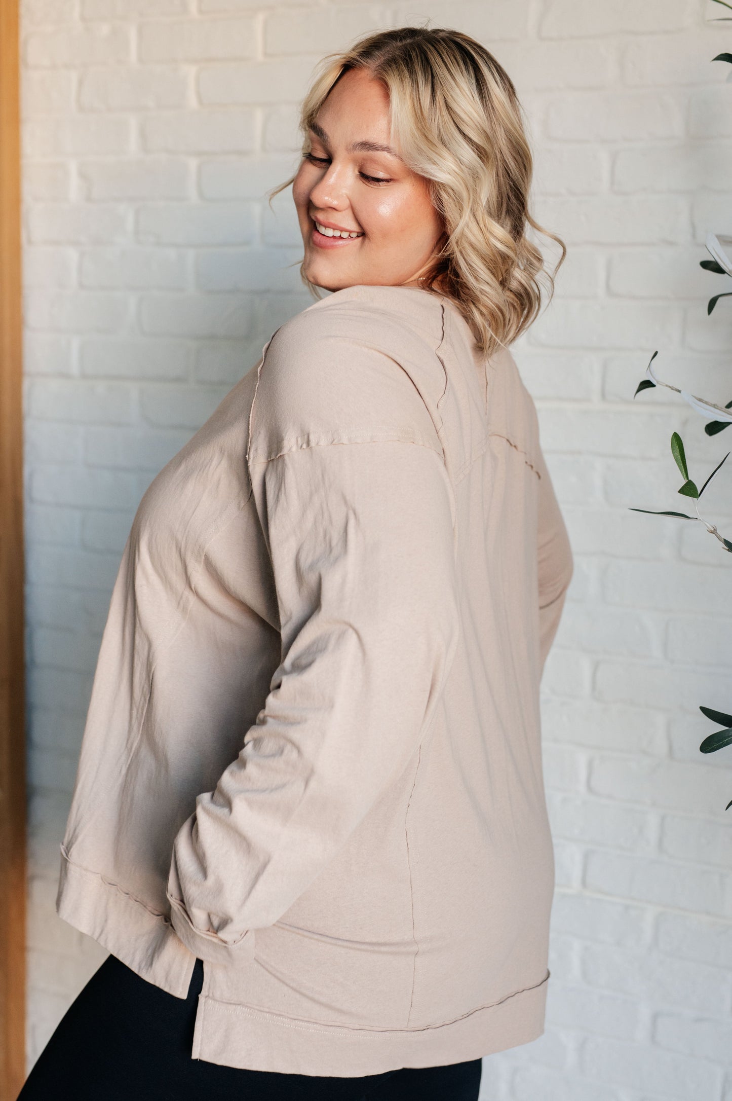 Plus size Haven Long Sleeve Top beige side view showing exposed seams and relaxed fit