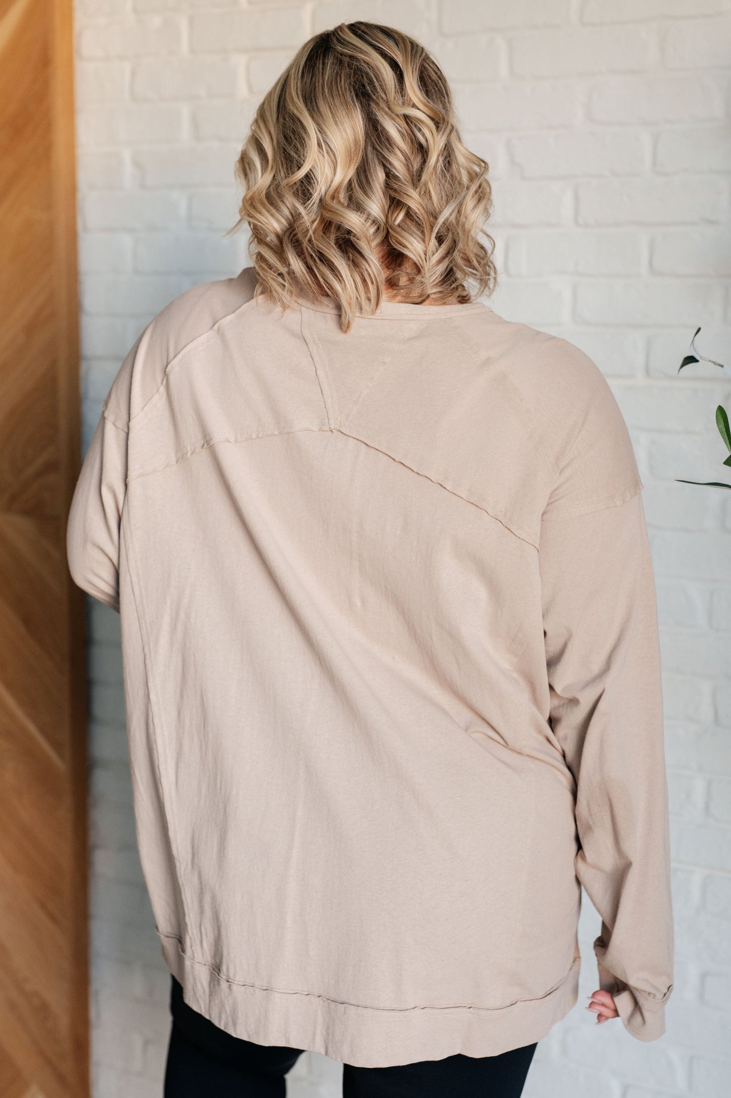 Plus size Haven Long Sleeve Top beige back view with exposed seams and stepped hem
