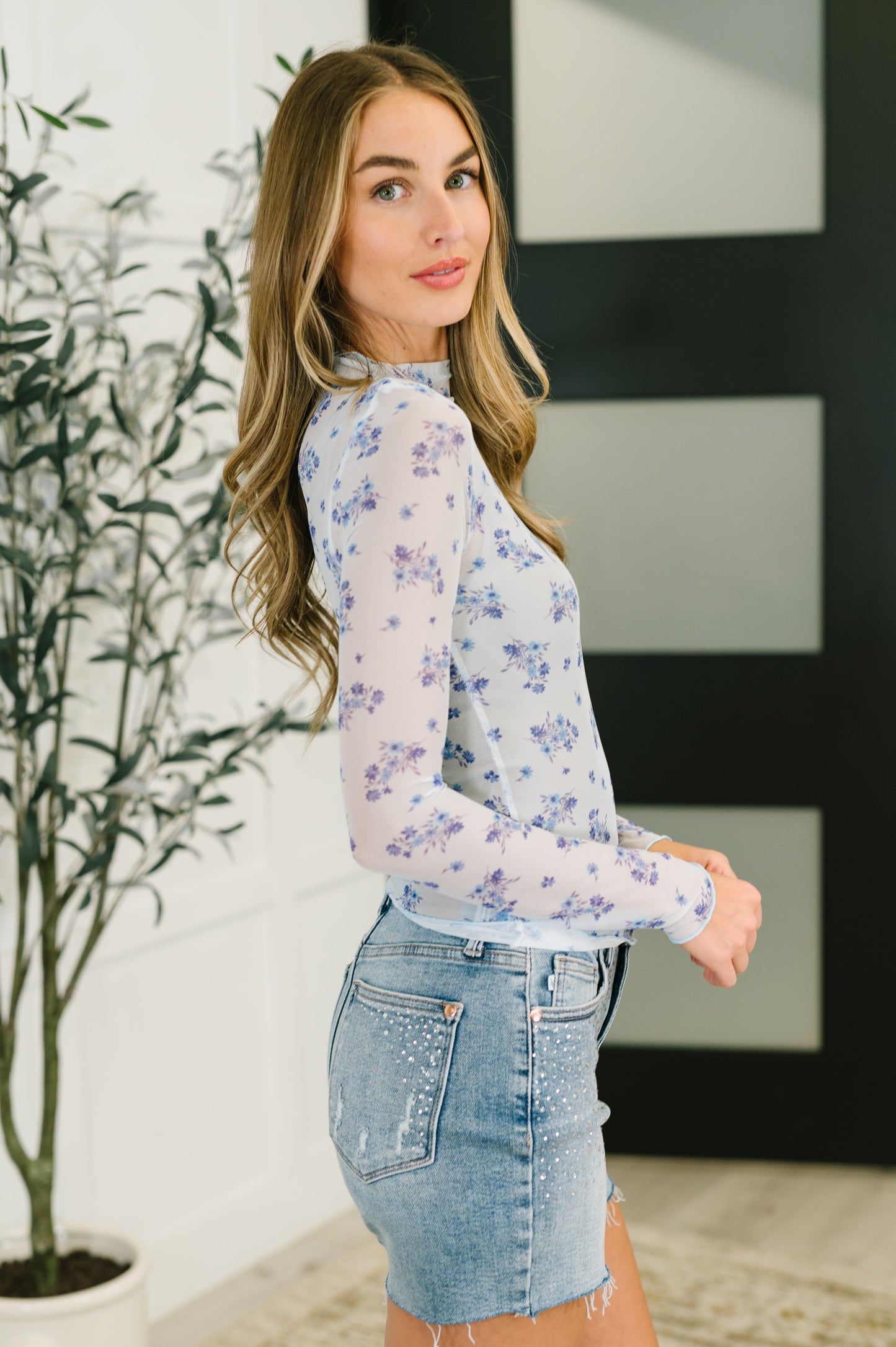 Side angle of Rosemary Sheer Mesh Top in light blue floral pattern with long sleeves and stretchy fit.