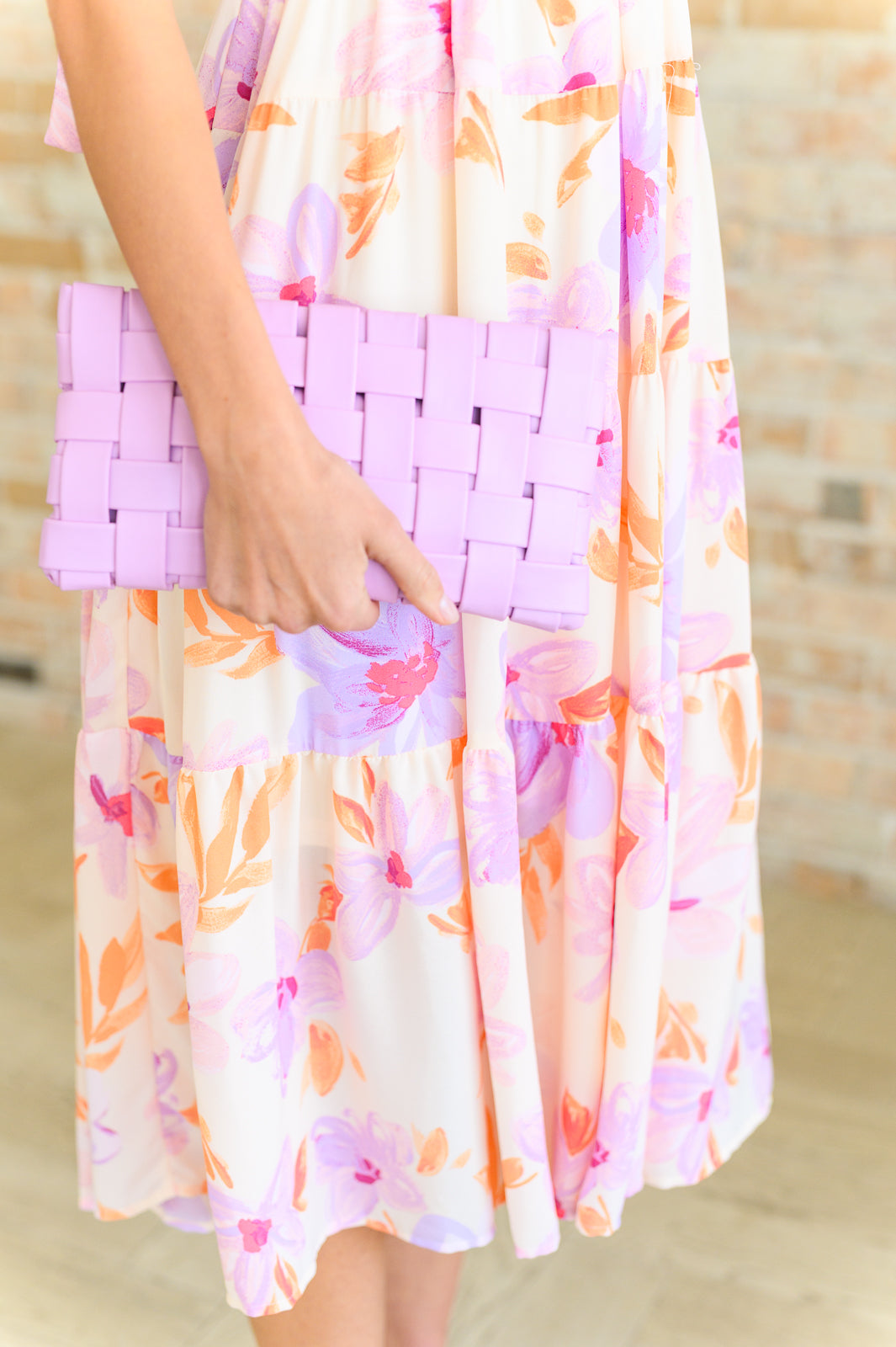 Close up of Lilia Basket Weave Lilac Purse being held as a clutch, envelope-style design with basket weave texture.