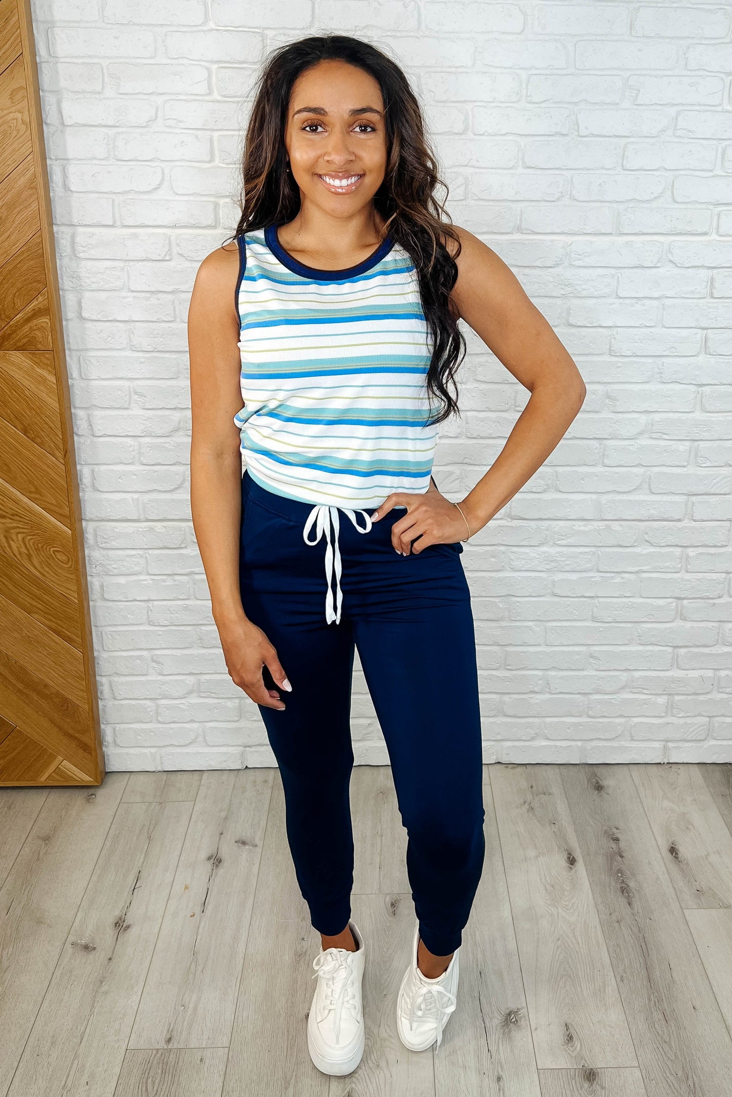 Full body shot of model wearing Genna navy joggers styled with sneakers and casual top.
