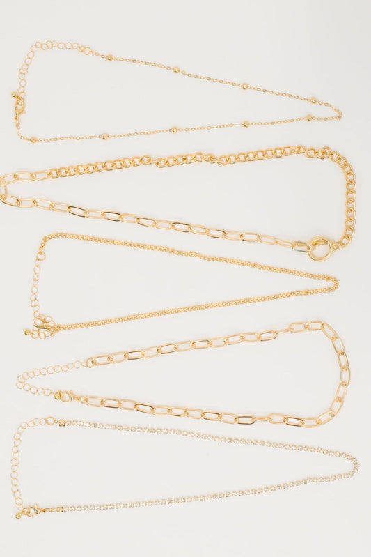 Flat lay of Golden Hour Links Everyday Set with layered gold chains and zircon accents.