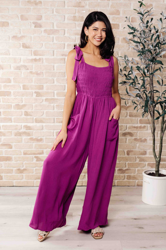 Model wearing Gracie Wide Leg Jumpsuit in purple with smocked bodice and wide leg fit.