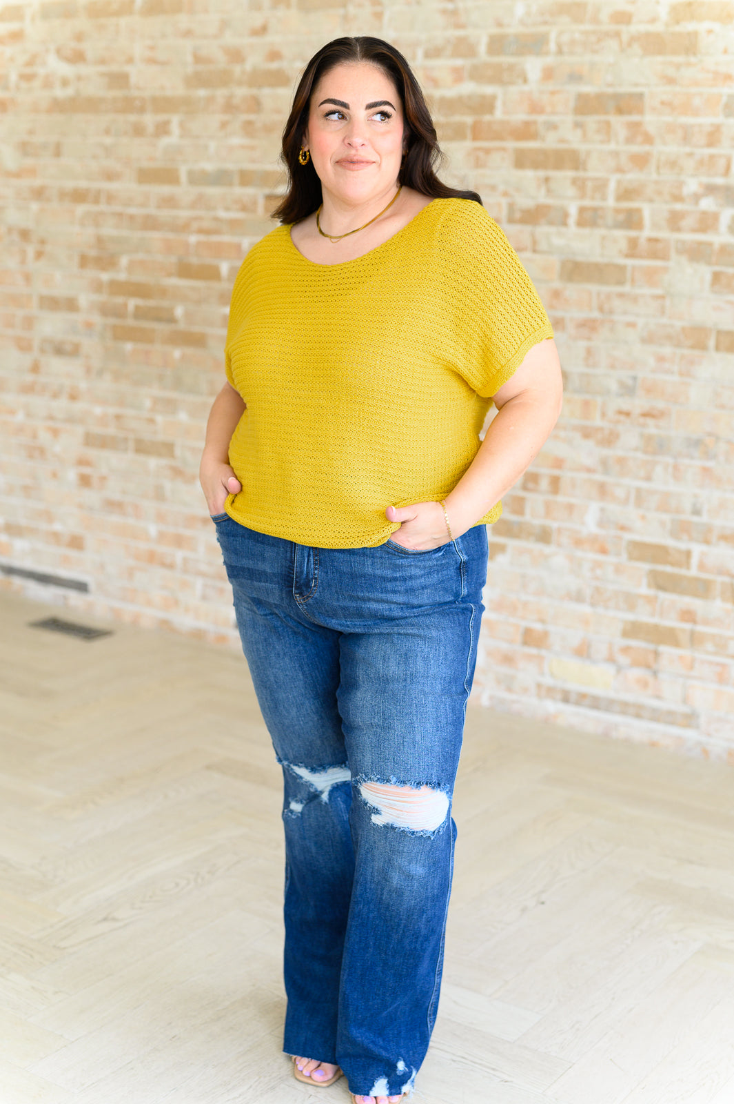 Plus model wearing Eliora Knit Top in saffron with scoop neck and dolman sleeves, styled with casual bottoms.
