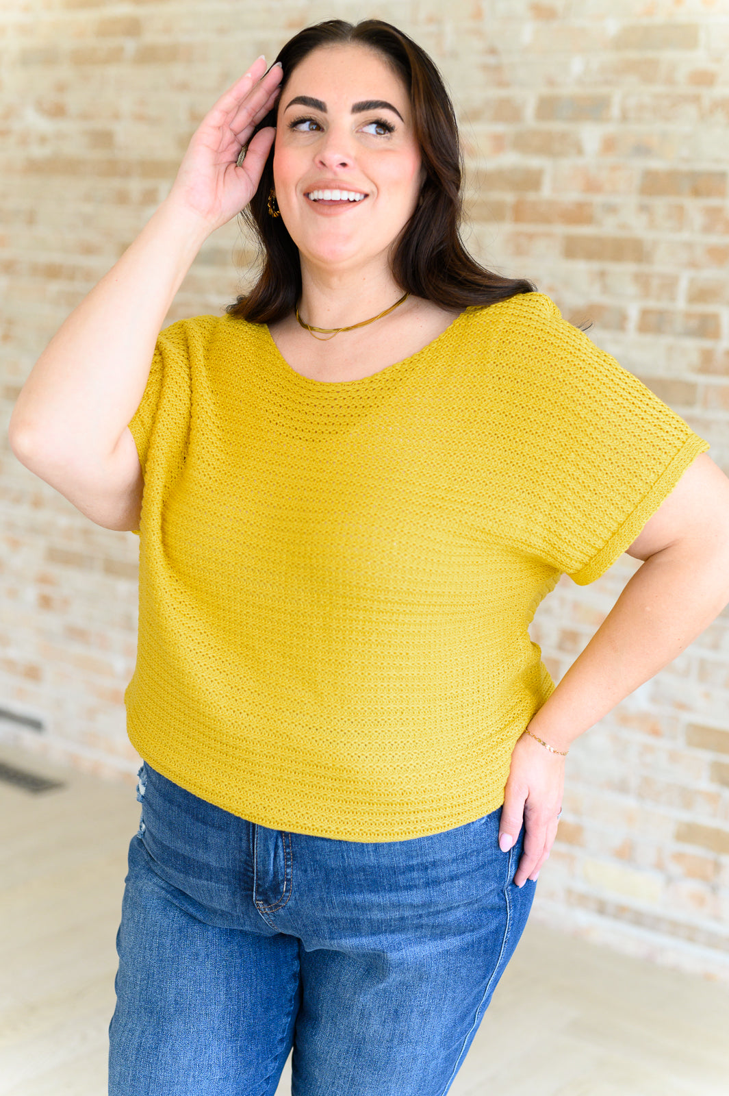 Plus model in saffron Eliora Knit Top with scoop neck and dolman sleeves, ribbed hemline for flattering fit.