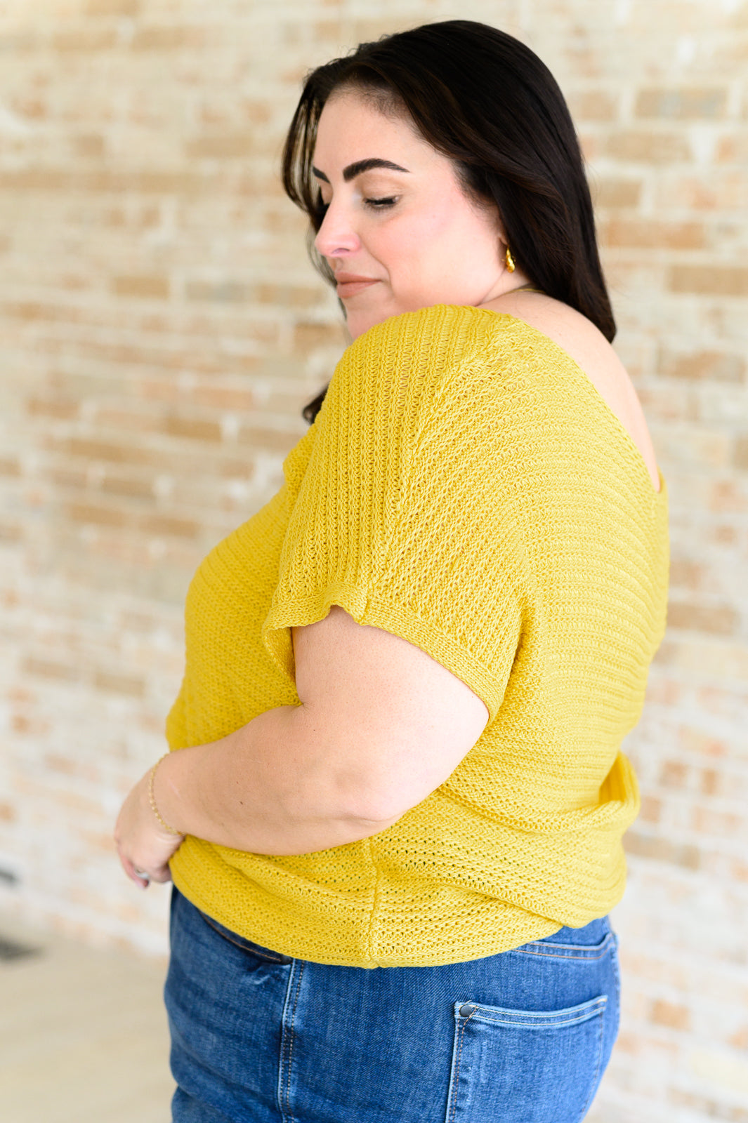 Plus size side view of saffron Eliora Knit Top showing scoop neckline, dolman sleeves, and ribbed hemline.