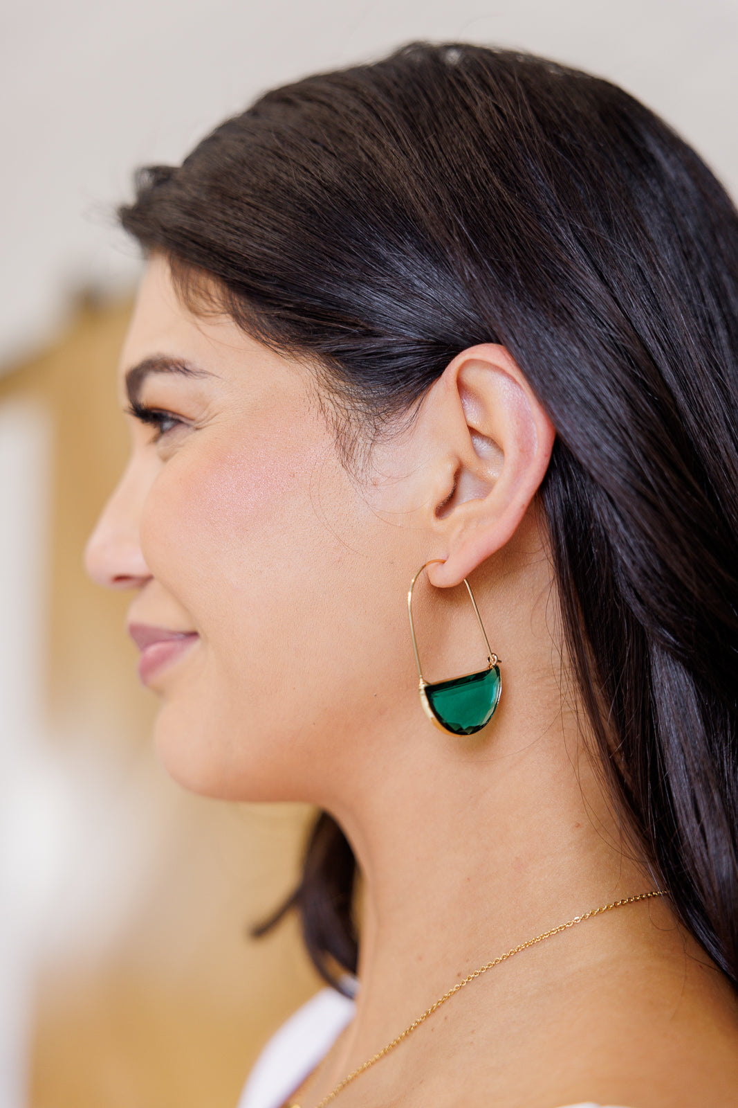 Woman wearing Half Circle Crystal Earrings in teal glass and gold plating, lightweight statement accessory.
