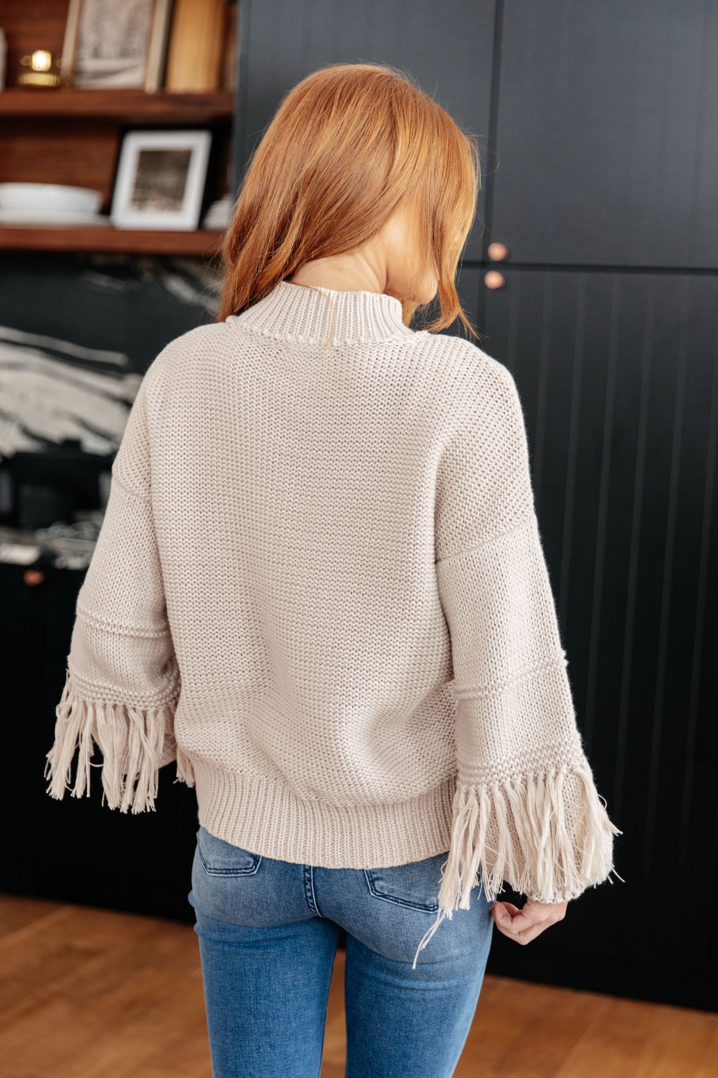 Back view of Haniya Fringe Detail Sweater highlighting fringe trim and relaxed knit design.
