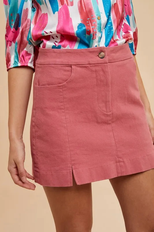 High waist rose mini skirt with slit detail and pockets.
