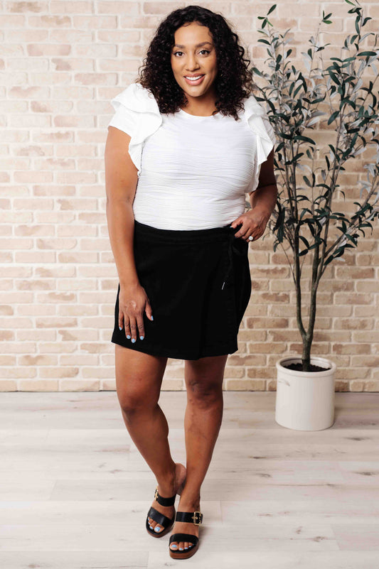 Plus-size model in Ila Blouse styled with jeans, showing flutter sleeves, round neckline, and relaxed fit.