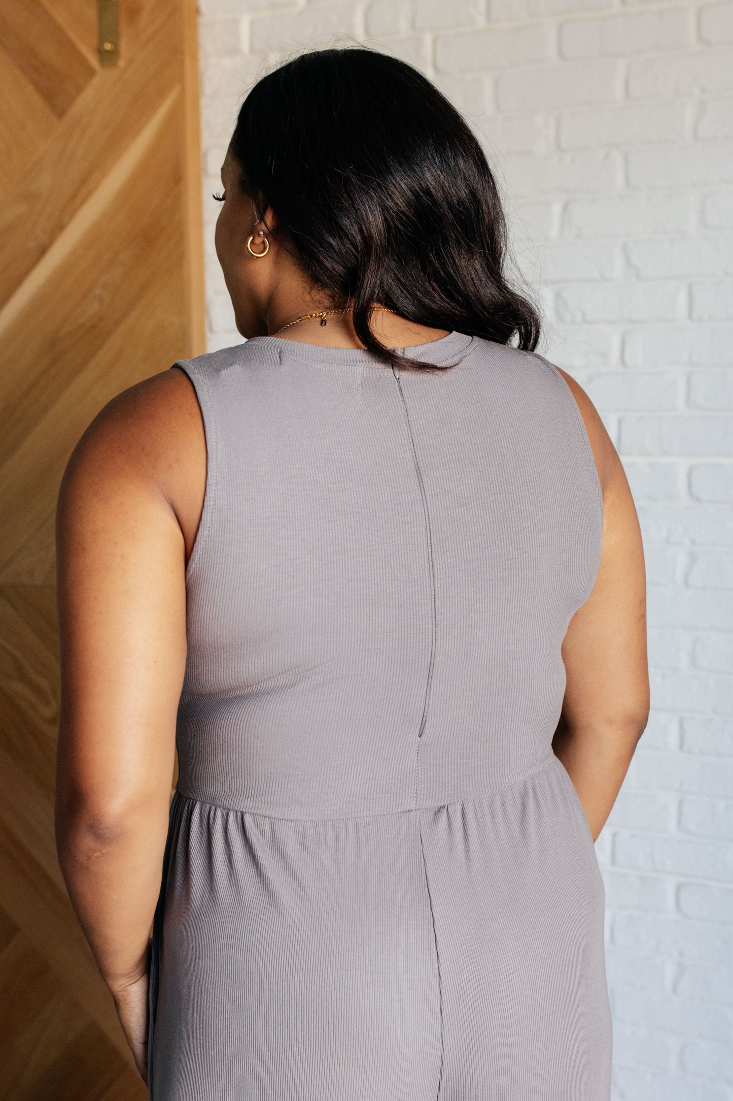 Plus size model back view of Hilary Jumpsuit with zipper closure, stretchy waistline, and soft ribbed fabric.