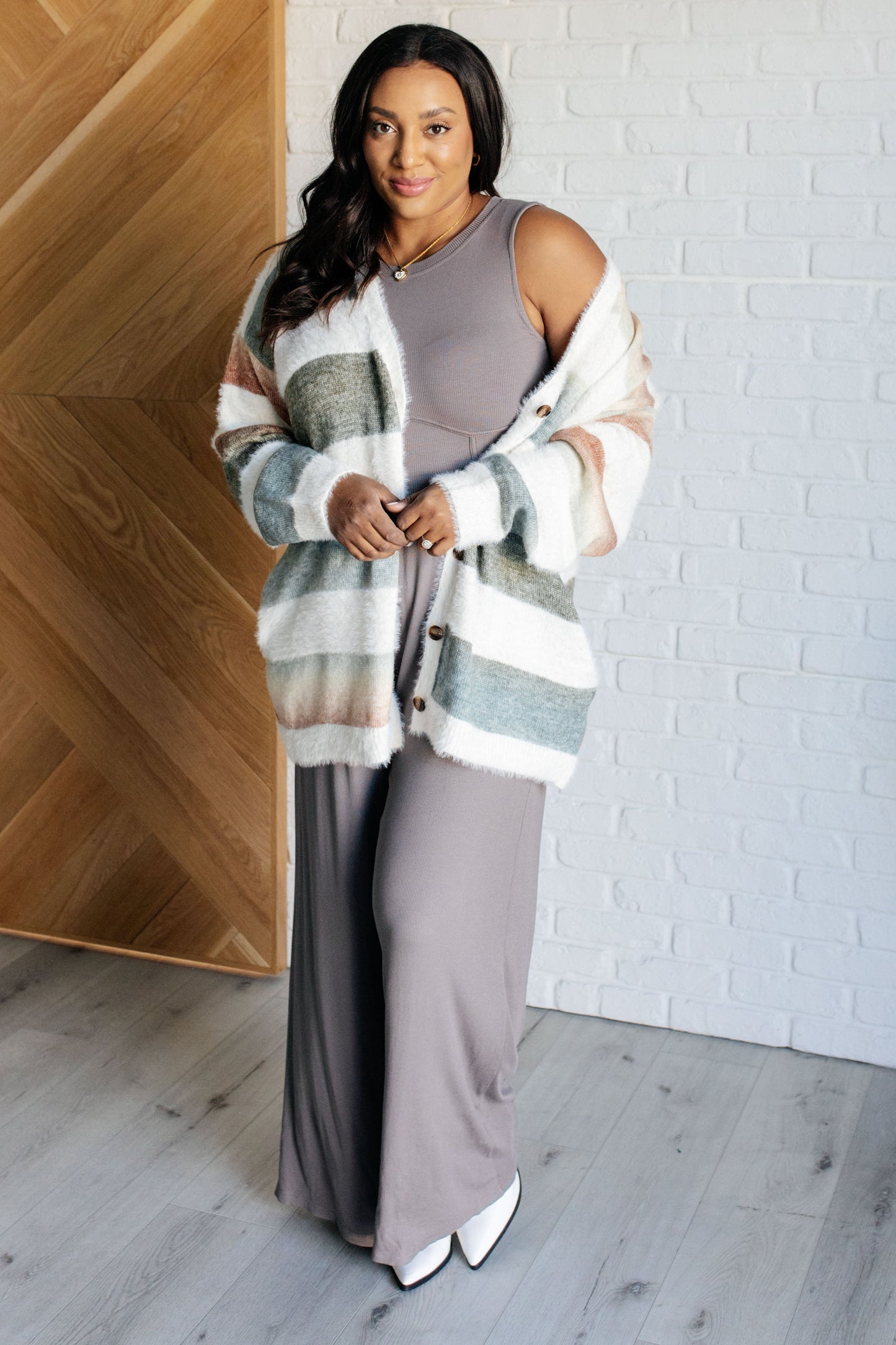 Plus size model wearing Hilary Jumpsuit layered with sweater, showing ribbed fabric, wide straps, and wide leg cut