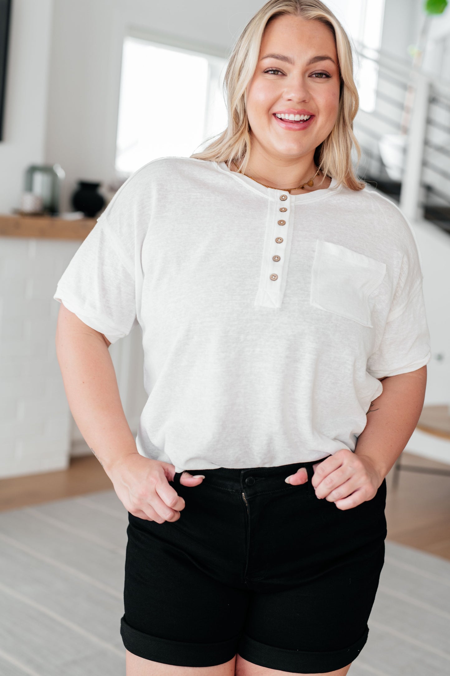 Plus size model wearing the Khloe Henley Top in ivory with drop shoulders, patch pocket, and scooped high-low hem.