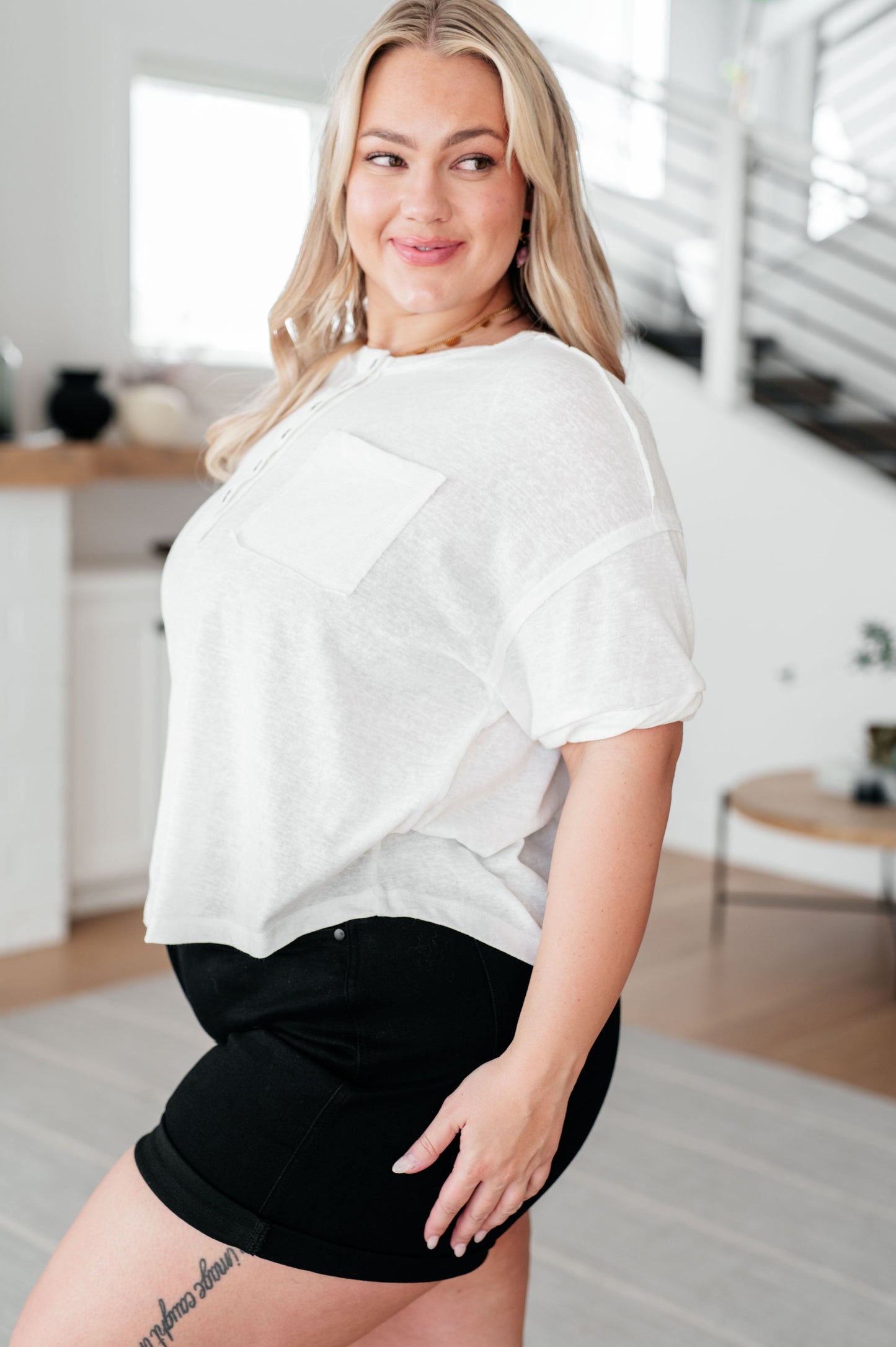 Plus size side view of Khloe Henley Top in ivory, highlighting scooped high-low hem and relaxed drop shoulder fit.