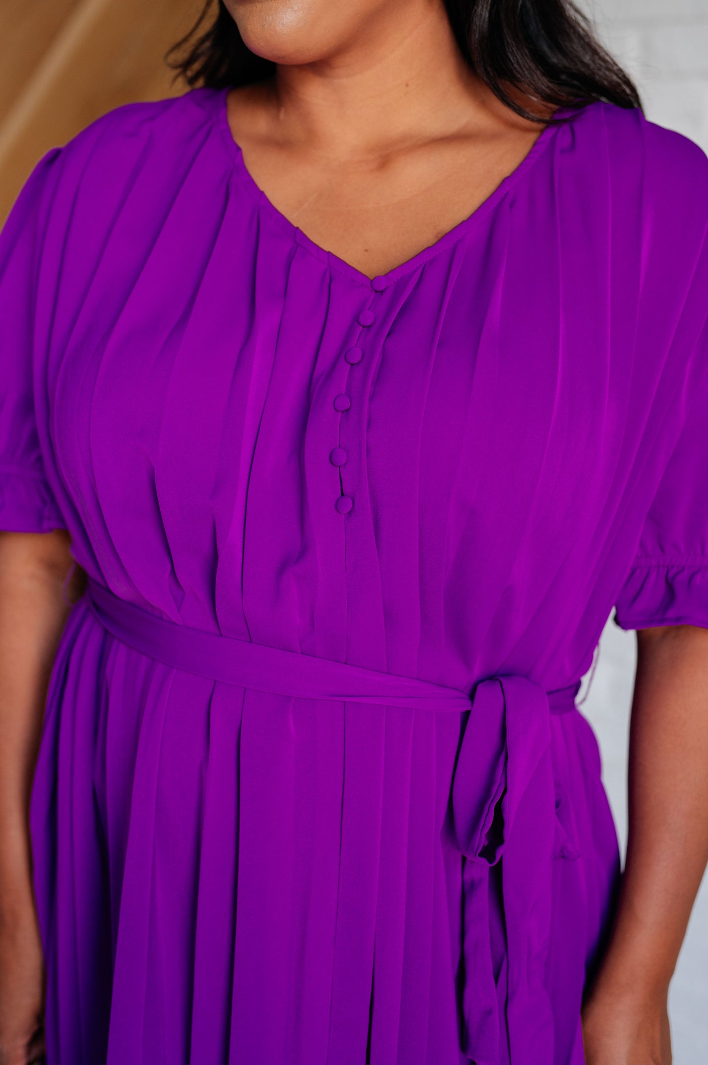 Close-up of Hoda Pleated Chiffon Dress highlighting button-up V-neckline, pleated chiffon, and puff sleeves.