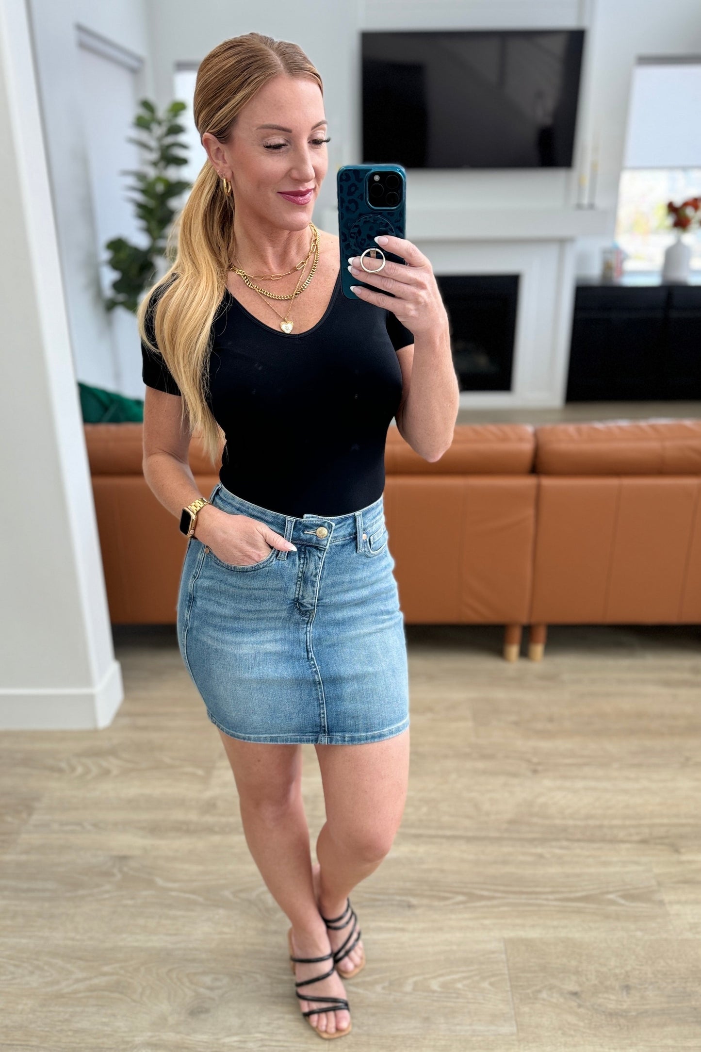 Medium wash Haley High Rise Denim Skirt by Judy Blue with a raw hem, control top technology, and zip fly closure for a classic and stylish look.