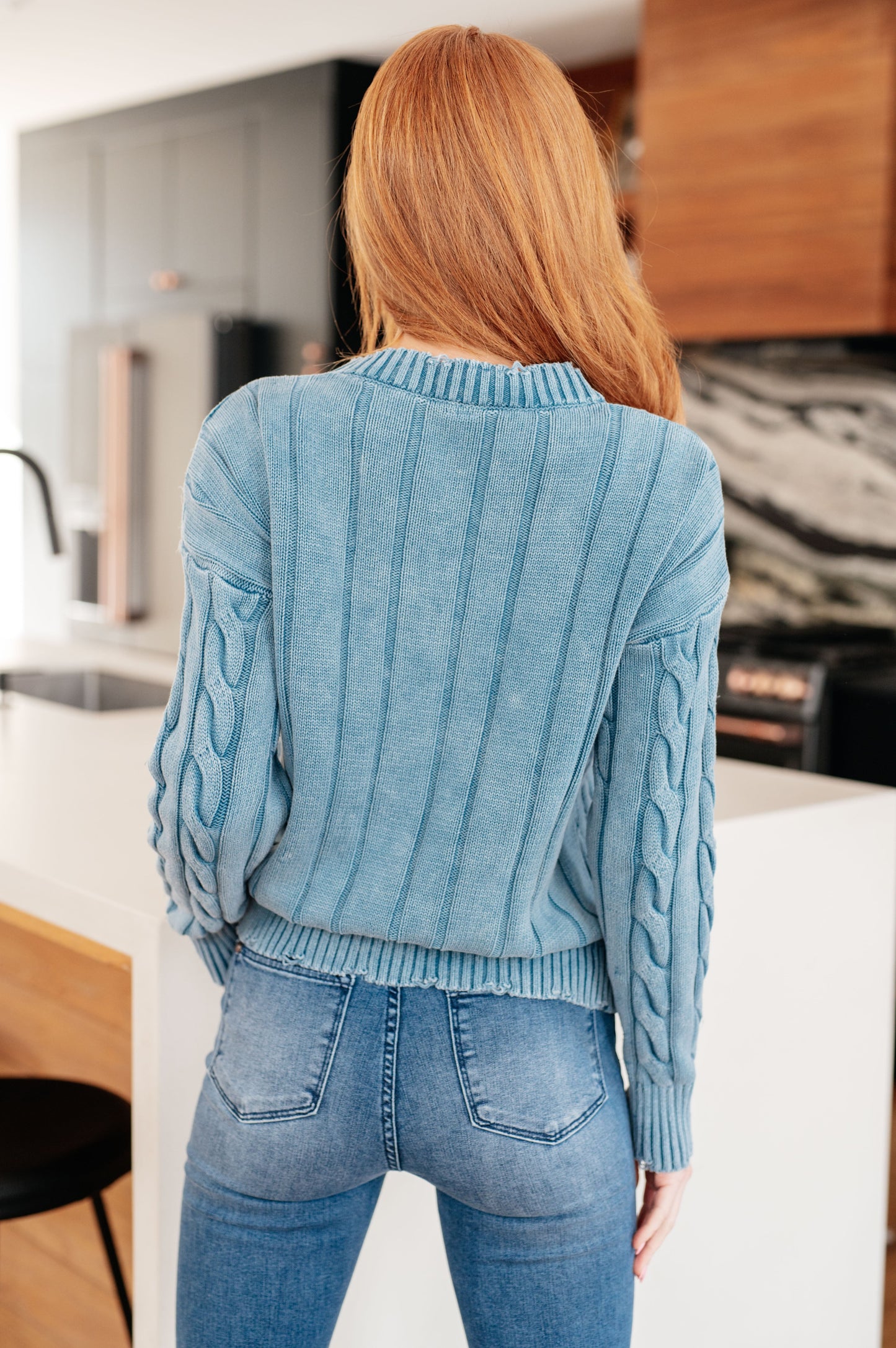 Back view of the Drea Cable Knit Sweater highlighting mineral wash and cable knit texture.