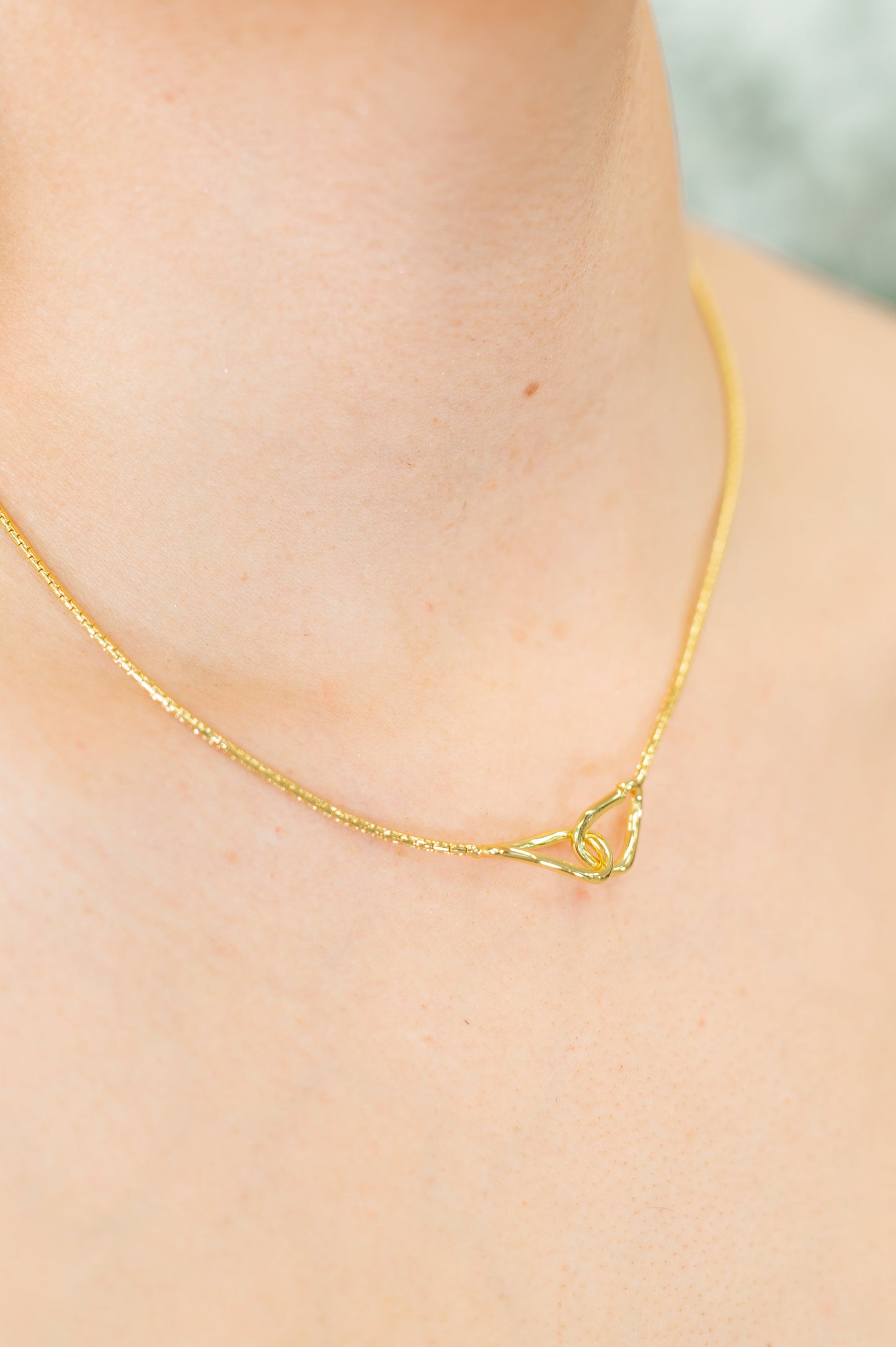 Woman wearing the I’ve Got You Necklace, showcasing the gold-plated chain with pendant and hoop closure.