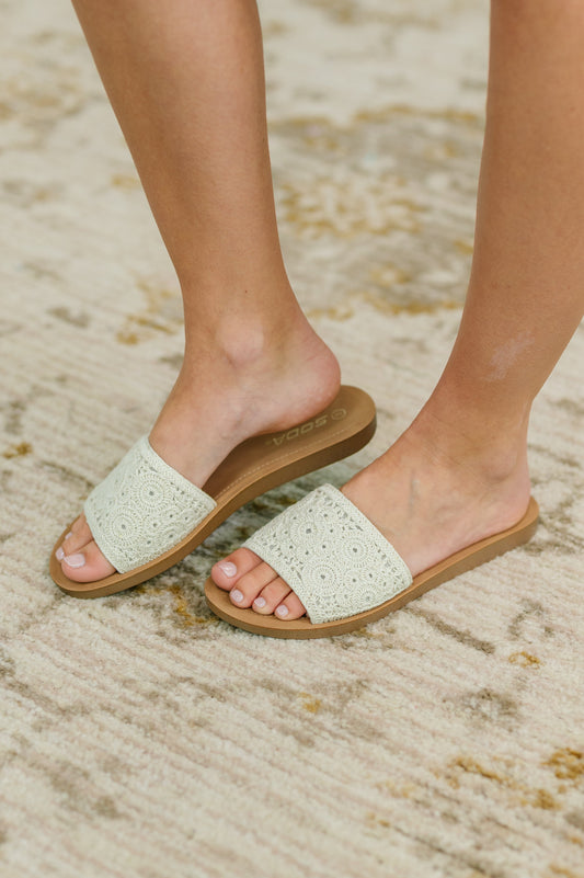Woman wearing Imelda Slip-On Sandal side view with off white macramé strap and rubber sole.
