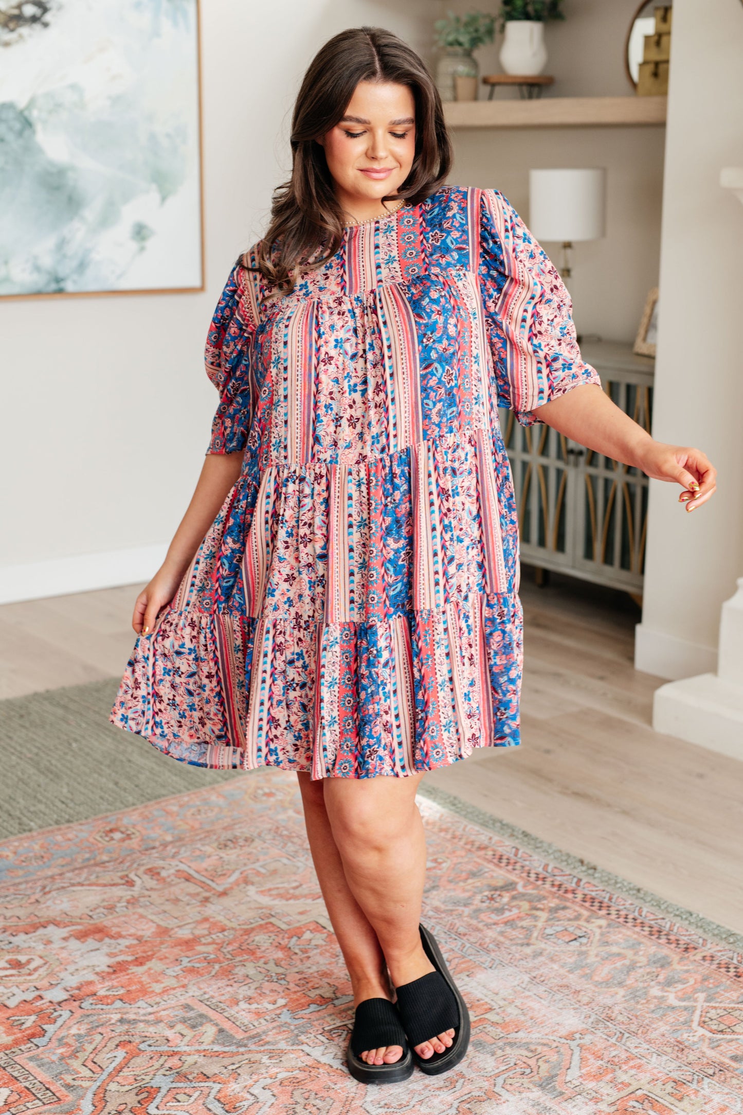Plus-size model wearing Rylee Tiered Dress in pink-and-blue floral print with sandals, full body view.