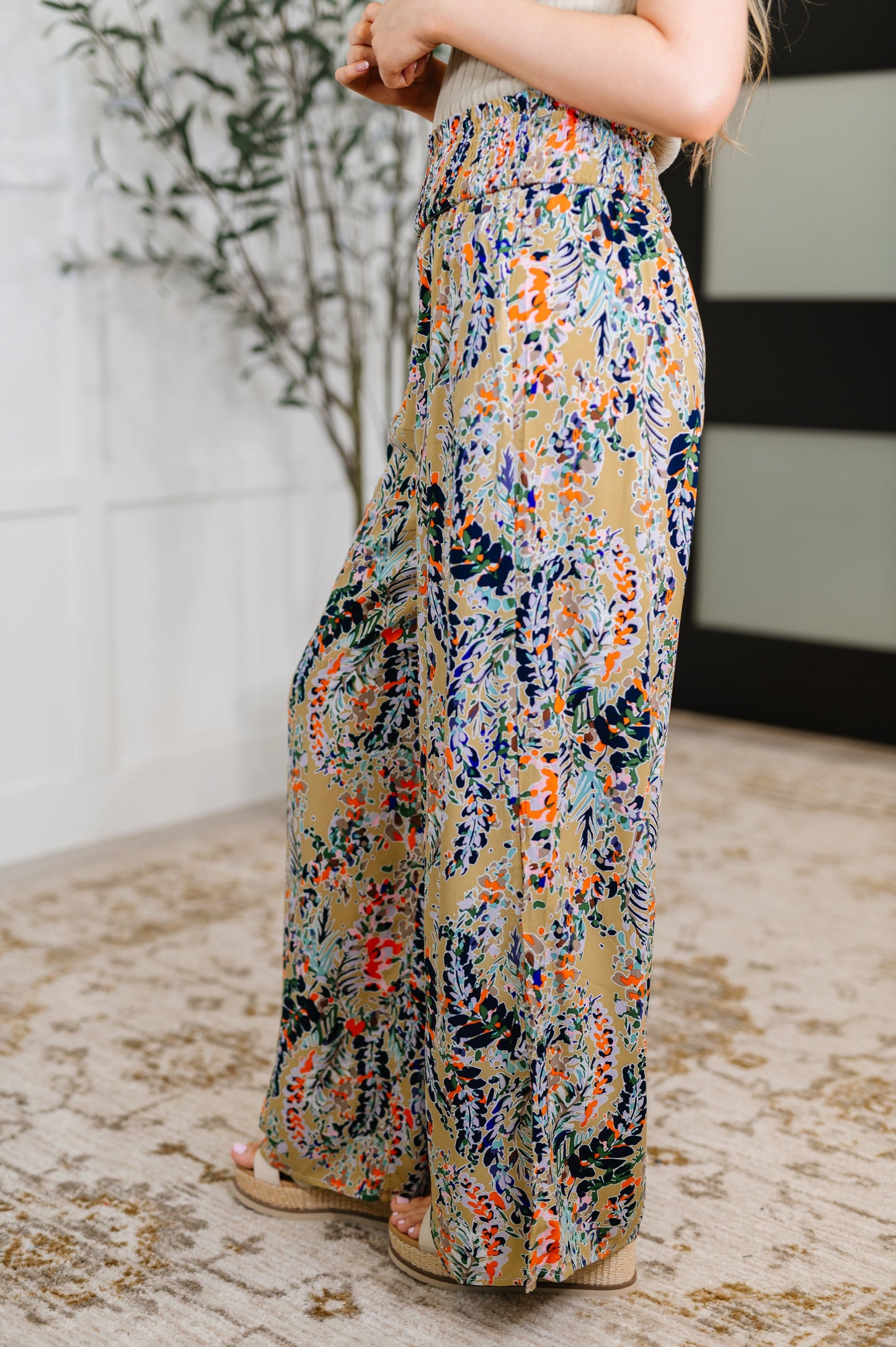 Side view of beige floral wide leg pants showing flowy wide leg silhouette.