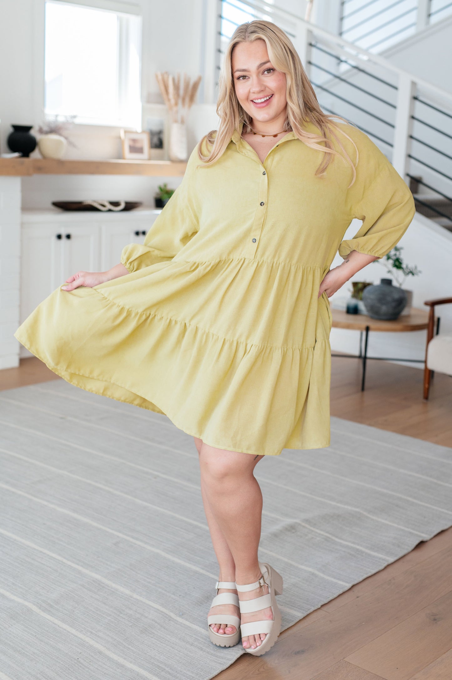 Plus size model wearing Jessie Tiered Mini Dress in pear green with puffed sleeves, tiered skirt, and functional buttons.