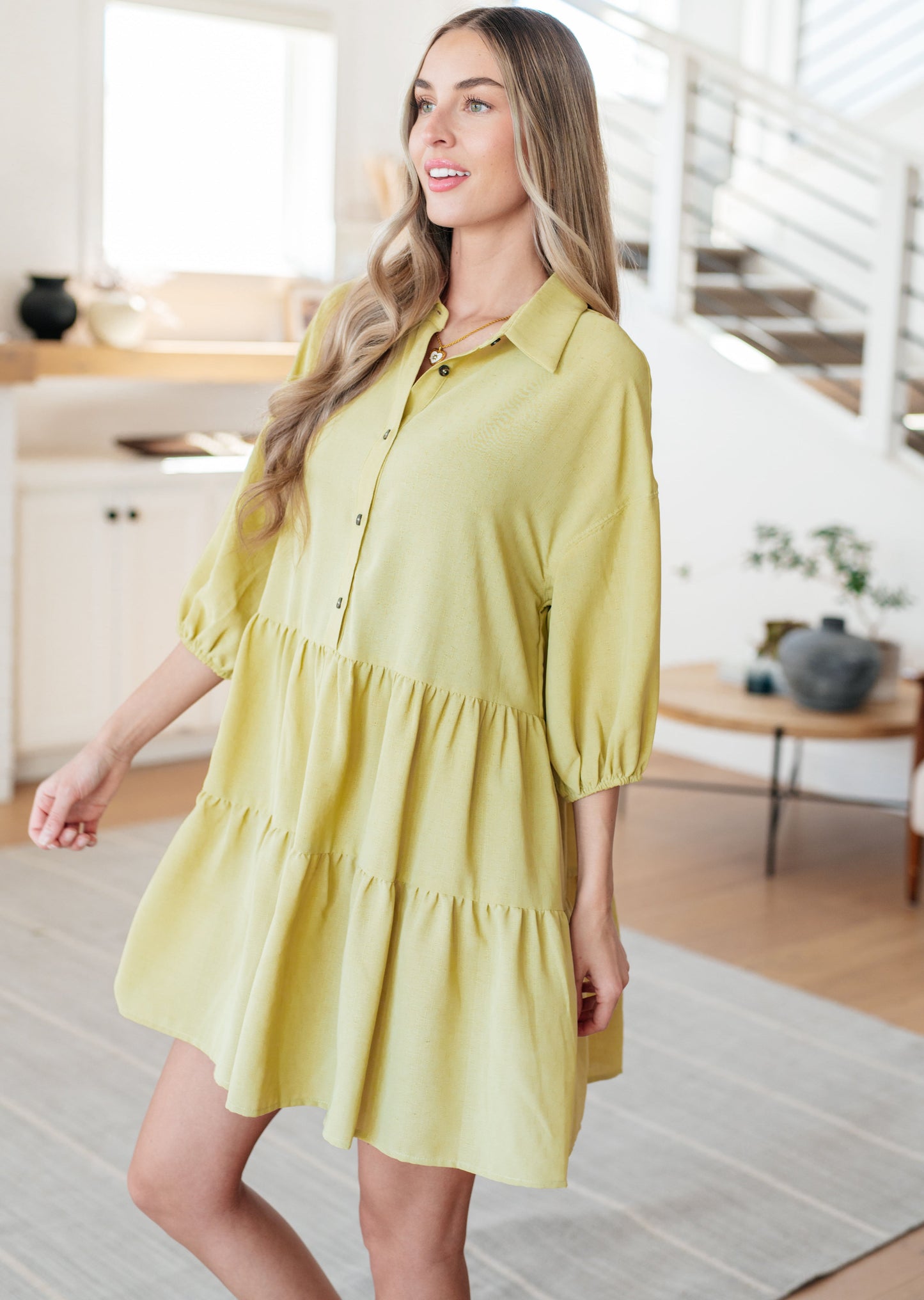Side view of Jessie Tiered Mini Dress in pear green highlighting puffed sleeves, tiered layers, and relaxed fit.