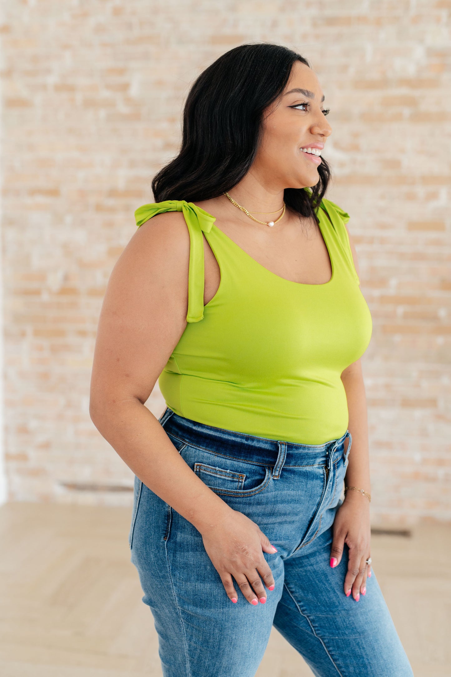 Plus size side view of Juska Bodysuit in lime green with adjustable straps, showing body-hugging fit and secure coverage.