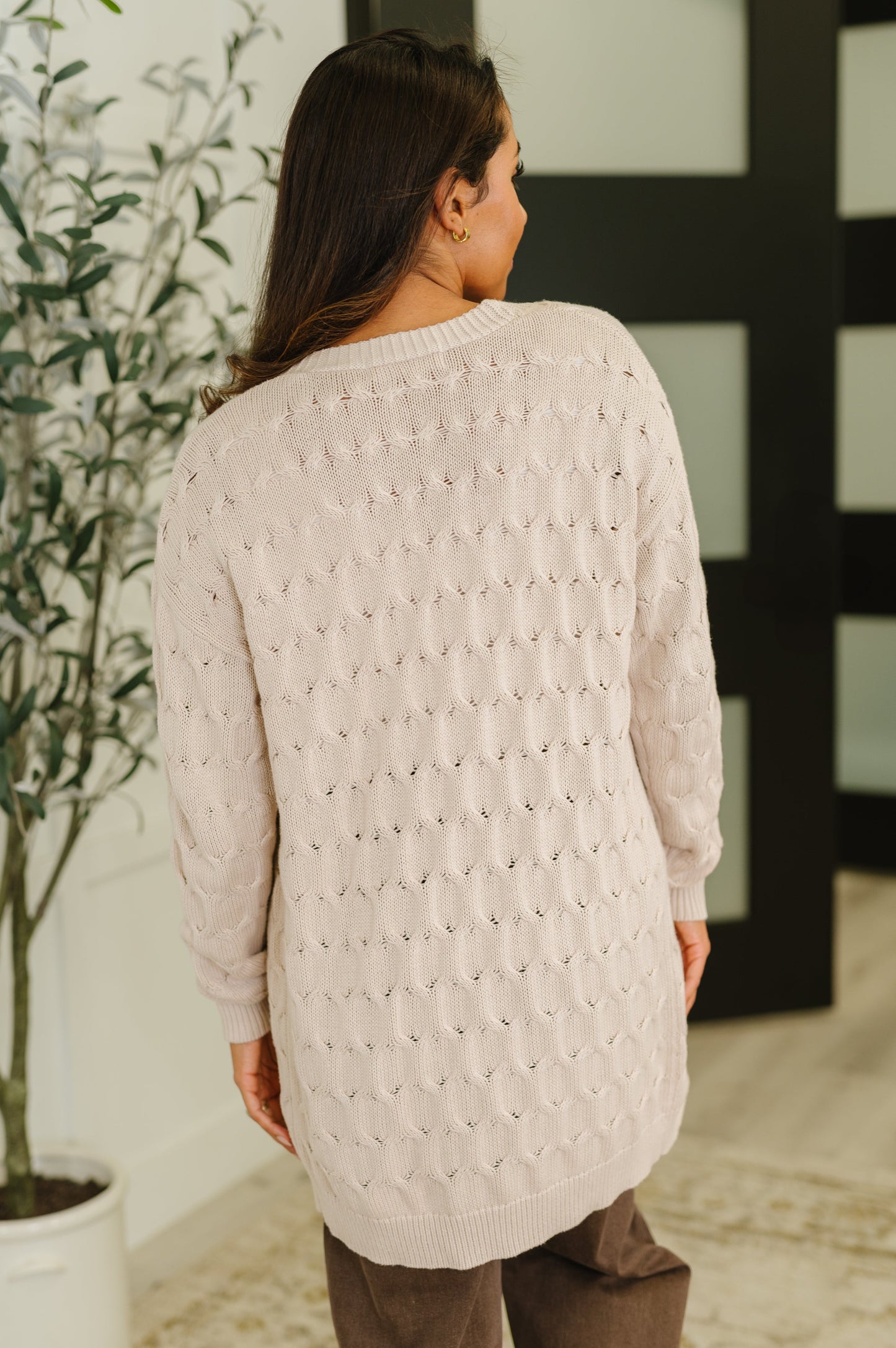 Back view of Juno Cable Knit Cardigan in beige with drop shoulder design