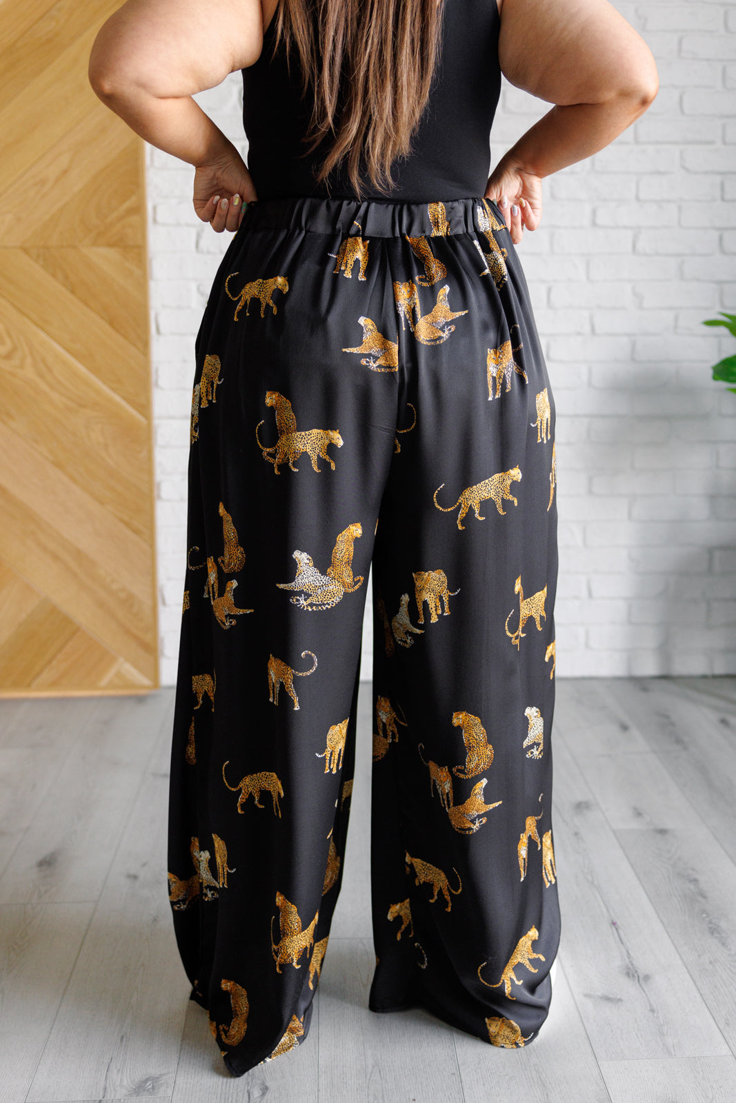 Plus size back view of Lyra Leopard Satin Wide Leg Pants with wide-leg silhouette, high-rise elastic waistband, and leopard imagery.