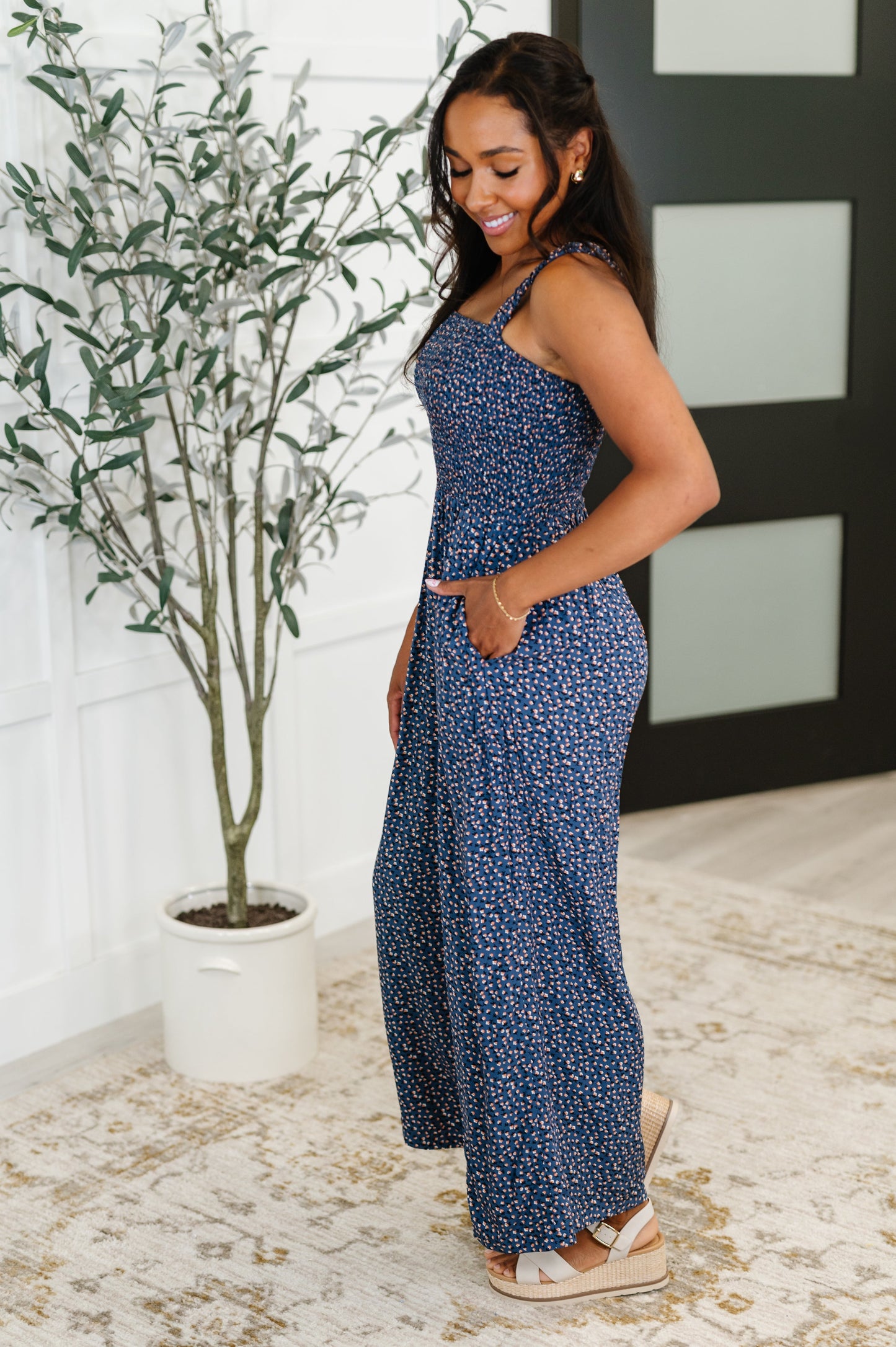 Side view of Libby Floral Jumpsuit in blue floral print with smocked bodice, wide-leg silhouette, and elastic straps.