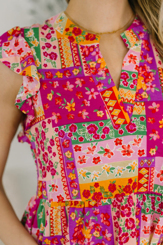 Close up of Lizzy Flutter Sleeve Dress in Pink Multi patchwork floral print detail.