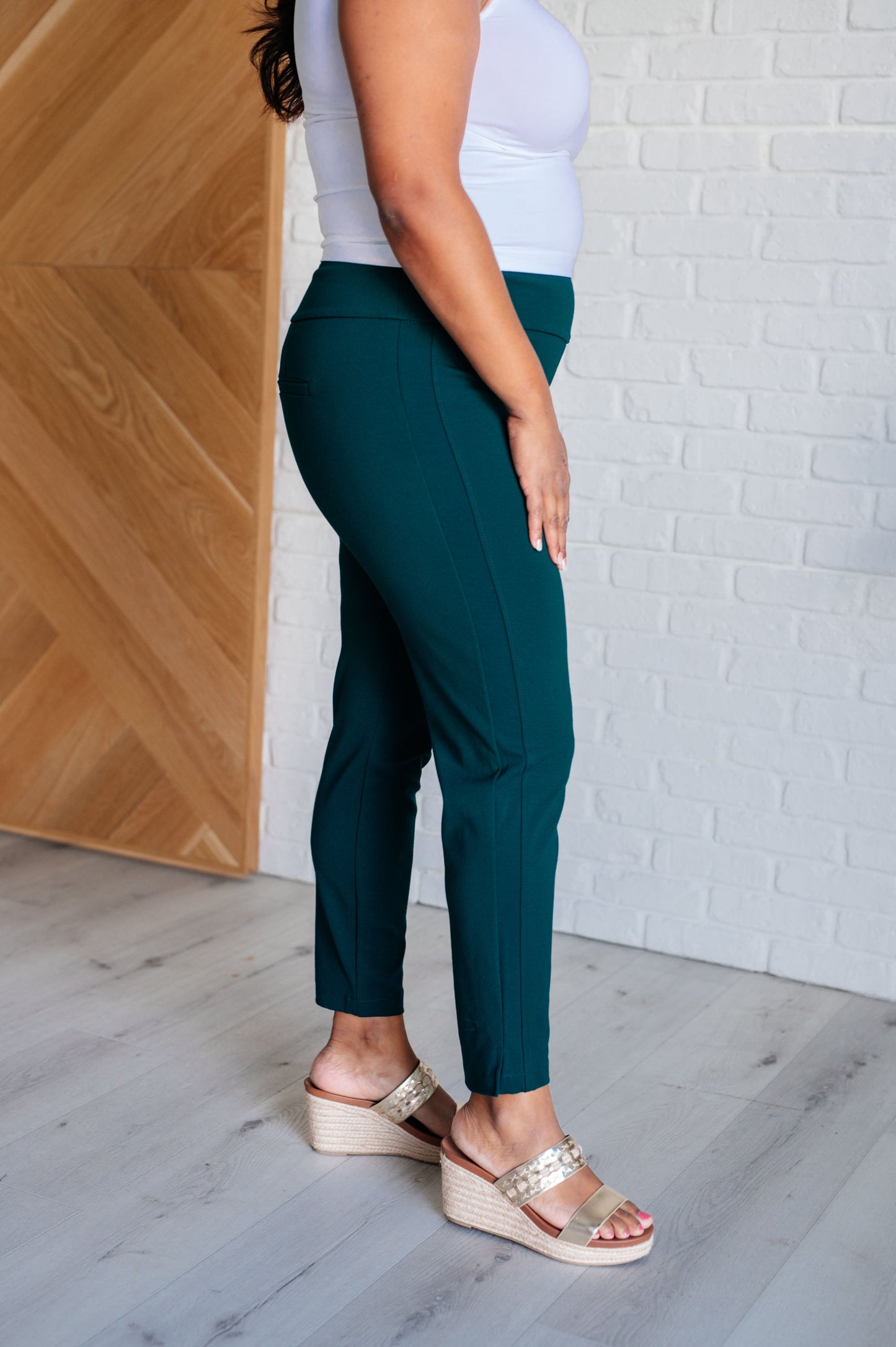 Plus size side view of Hunter Green Midge Magic Skinny Pants with sleek tuxedo stripe.