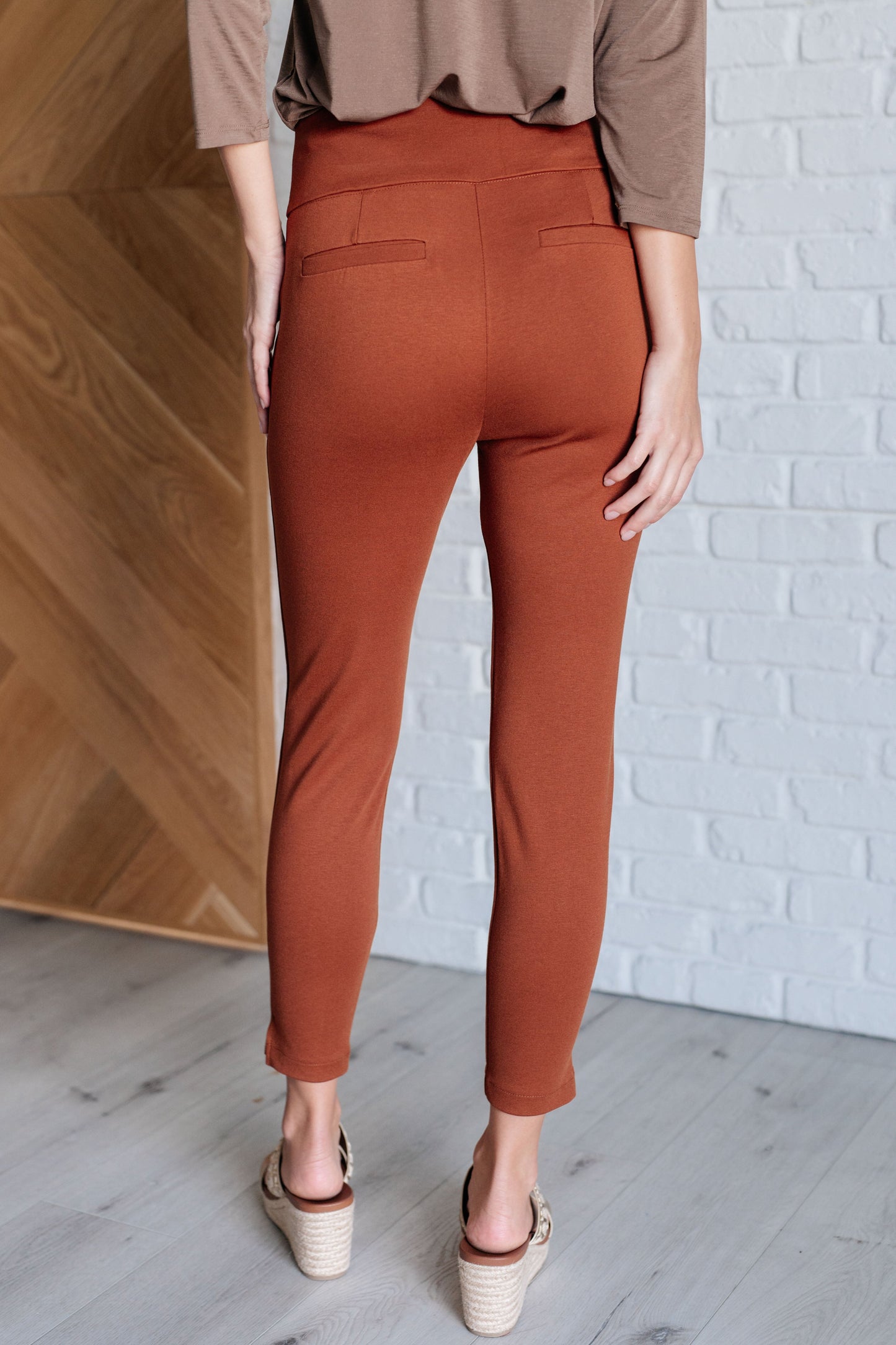 Back view of Rust Midge Magic Skinny Pants with slim silhouette, faux welt pocket detail, and ankle crop hem.