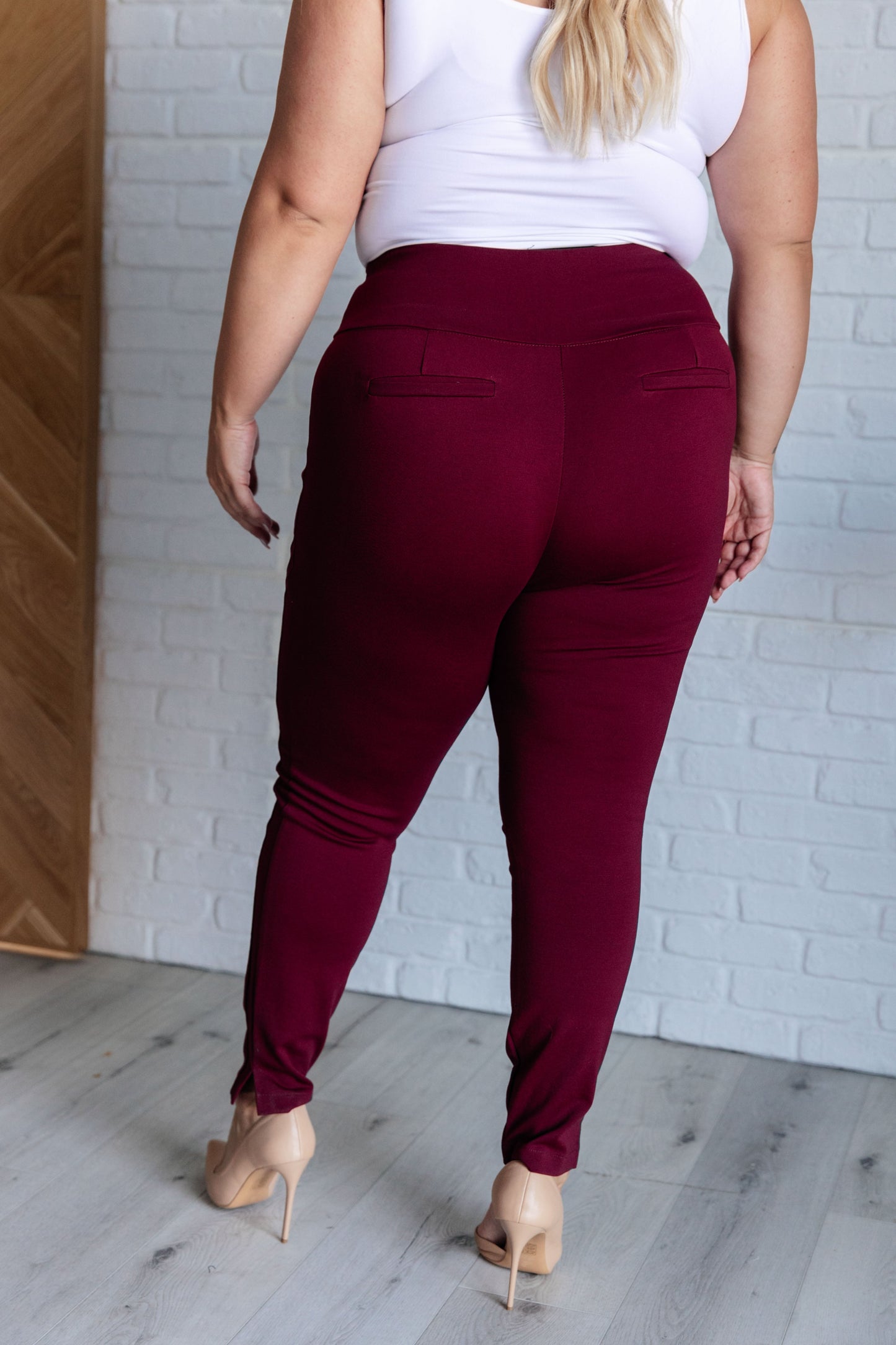 Plus-size back view of wine skinny pants with tuxedo stripes and flattering slim fit cut.