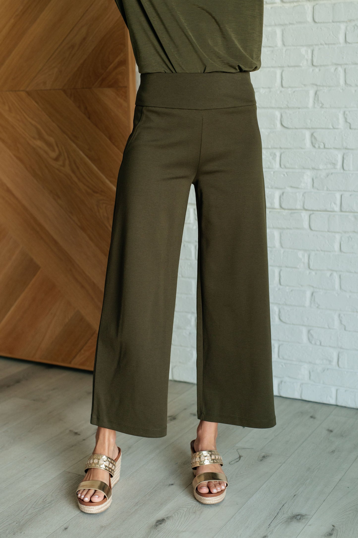 Olive ponte knit wide leg crop pants with high-rise fit, cropped hem, and faux welt pocket detail.